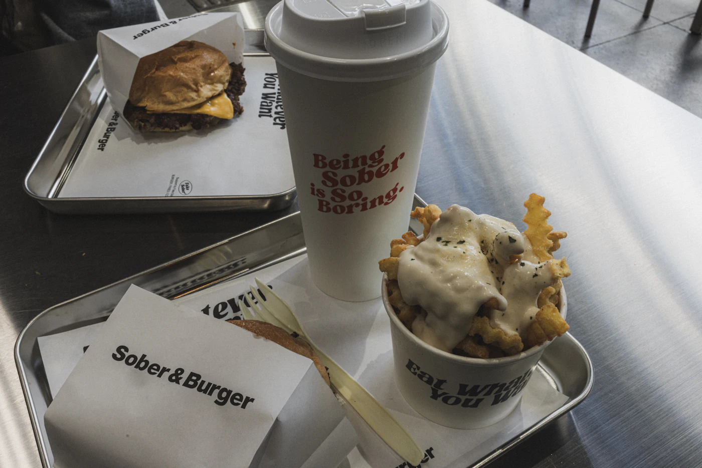 Burger, frites et boisson servis sur un plateau en métal réutilisable