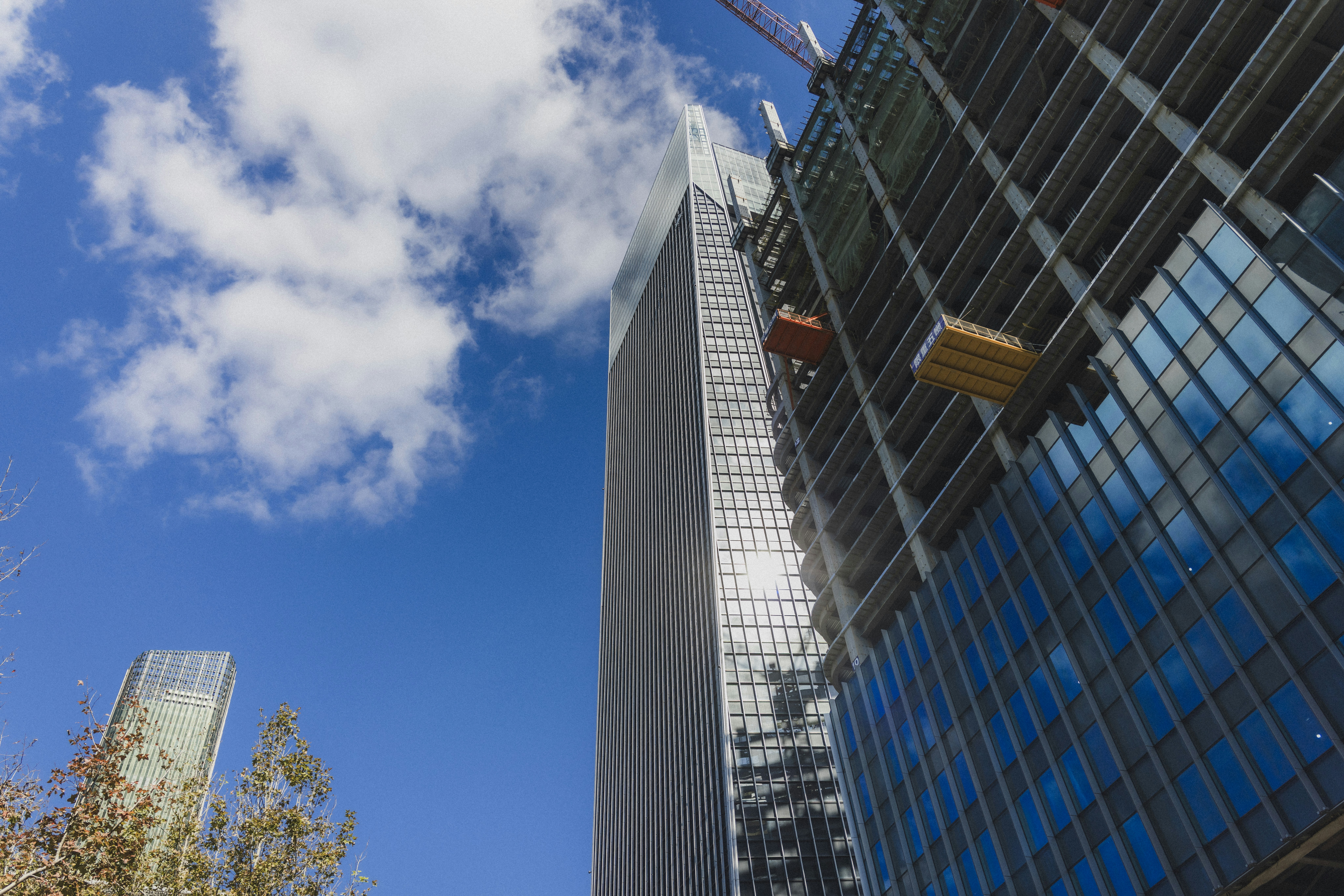 Modern skyscrapers under a bright blue sky.
