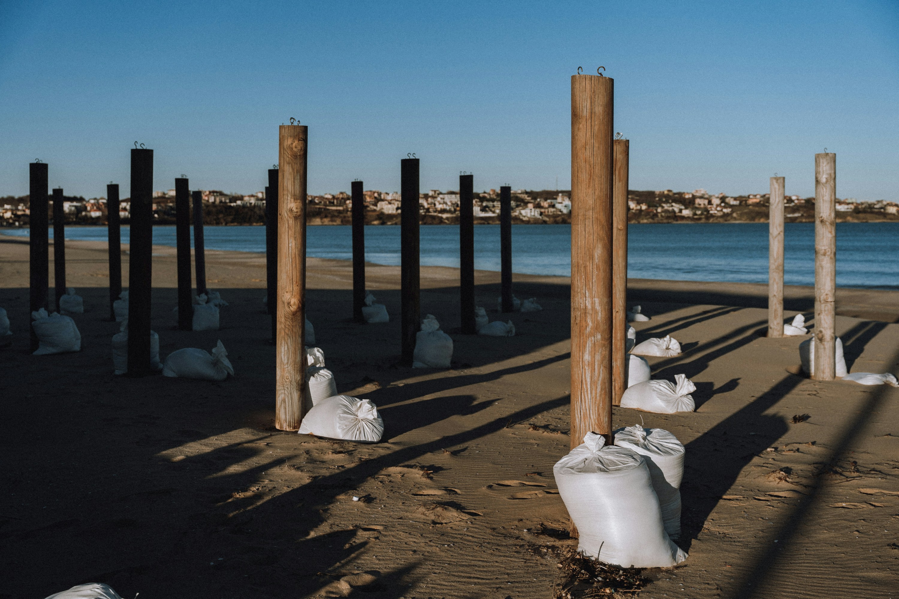 Wooden posts with sandbags on a beach
