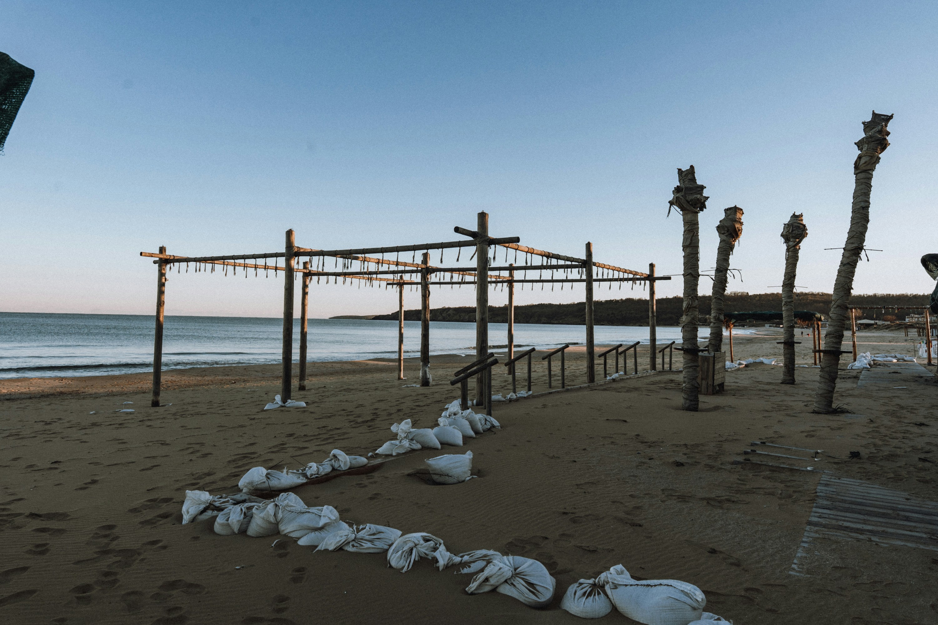 Empty beach with sandbags and wooden structures