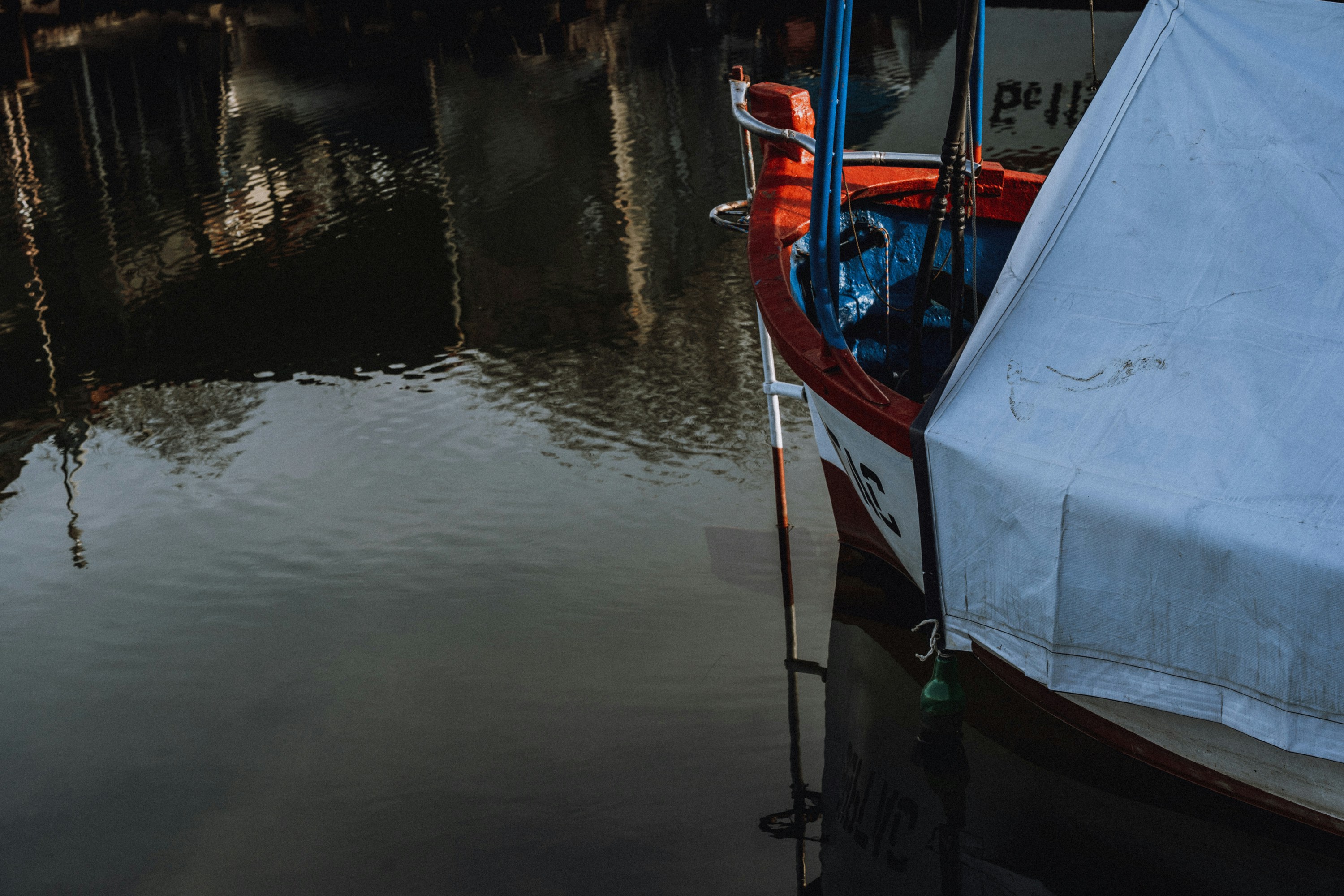 A boat docked on calm water with reflections