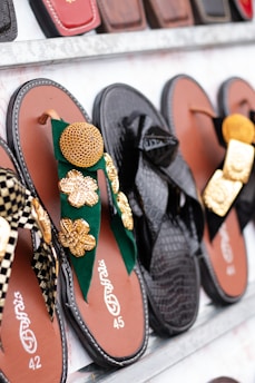 Row of decorative women's sandals displayed on a shelf.