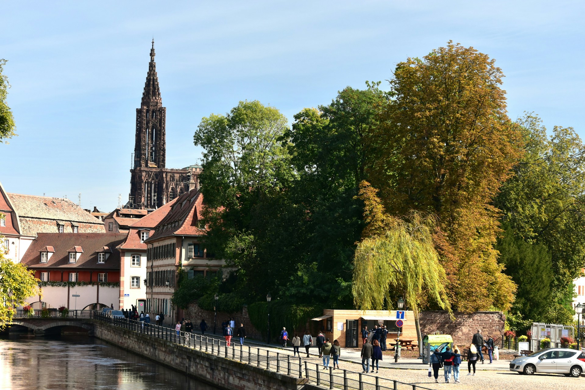 Historic buildings and trees line a canal promenade.