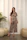 Woman in patterned pajama set standing indoors.