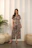 Woman in patterned pajama set standing indoors.
