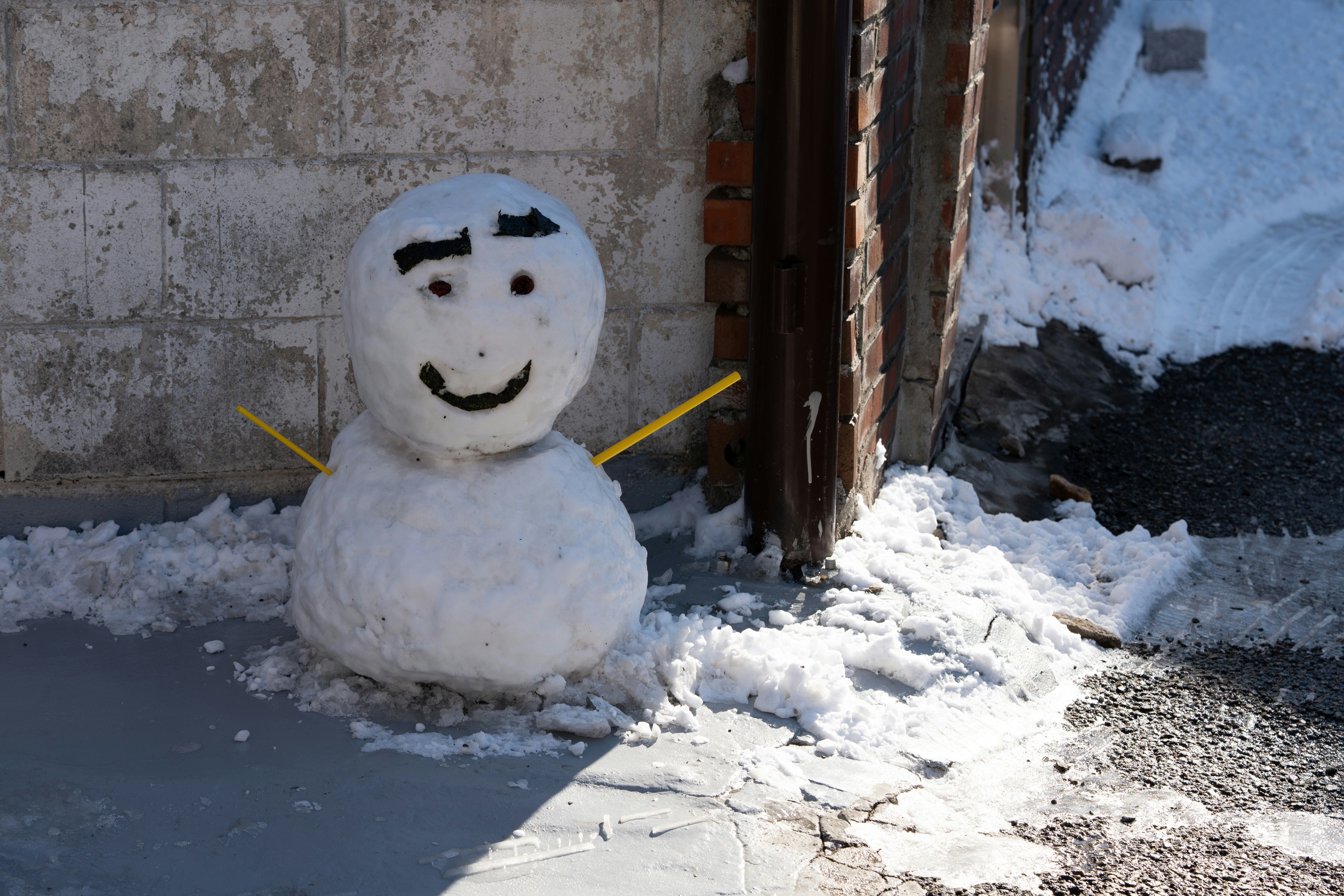 A snowman with a drawn-on face stands outside.