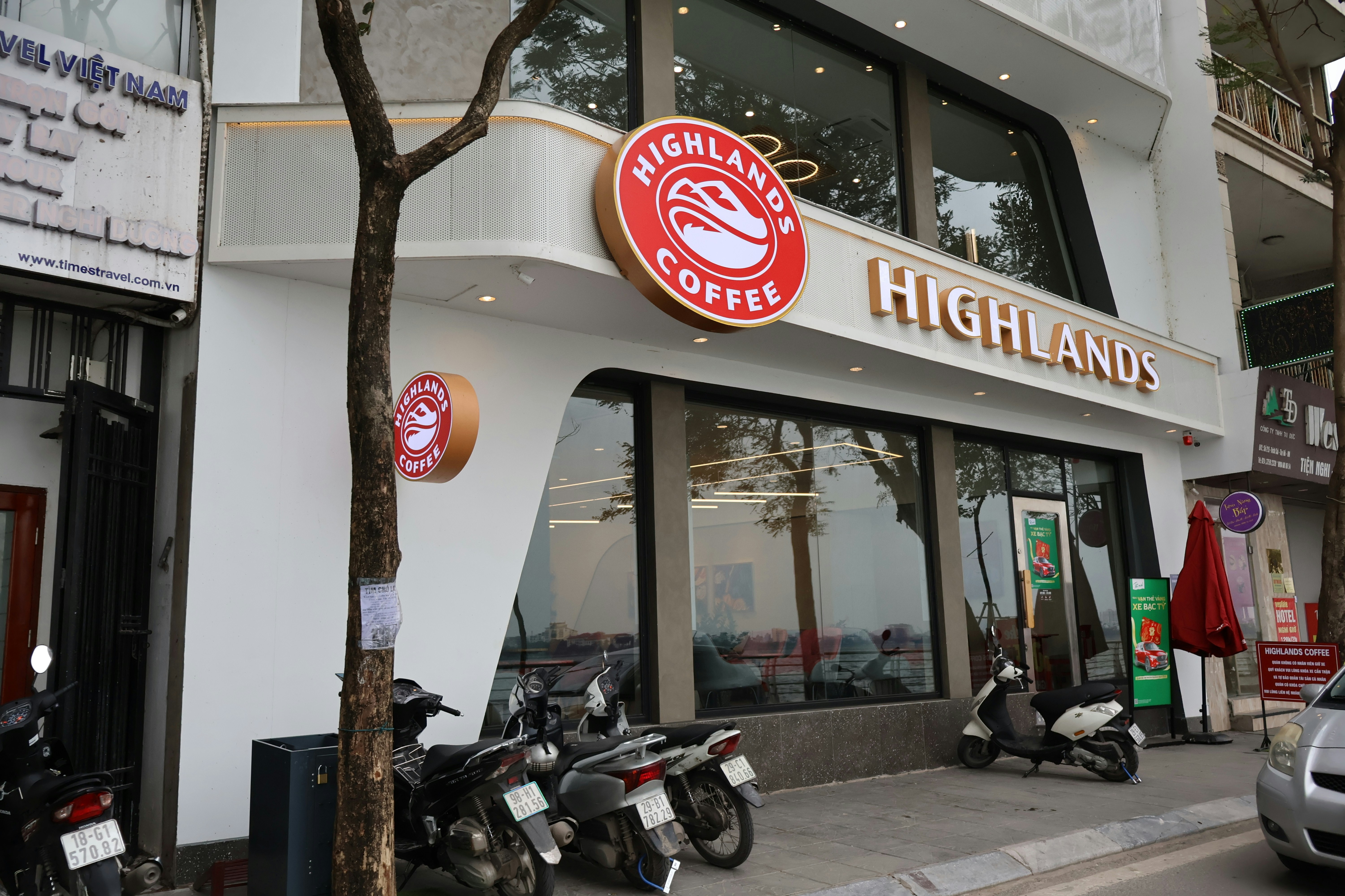 Exterior of a highlands coffee shop with motorcycles parked outside.