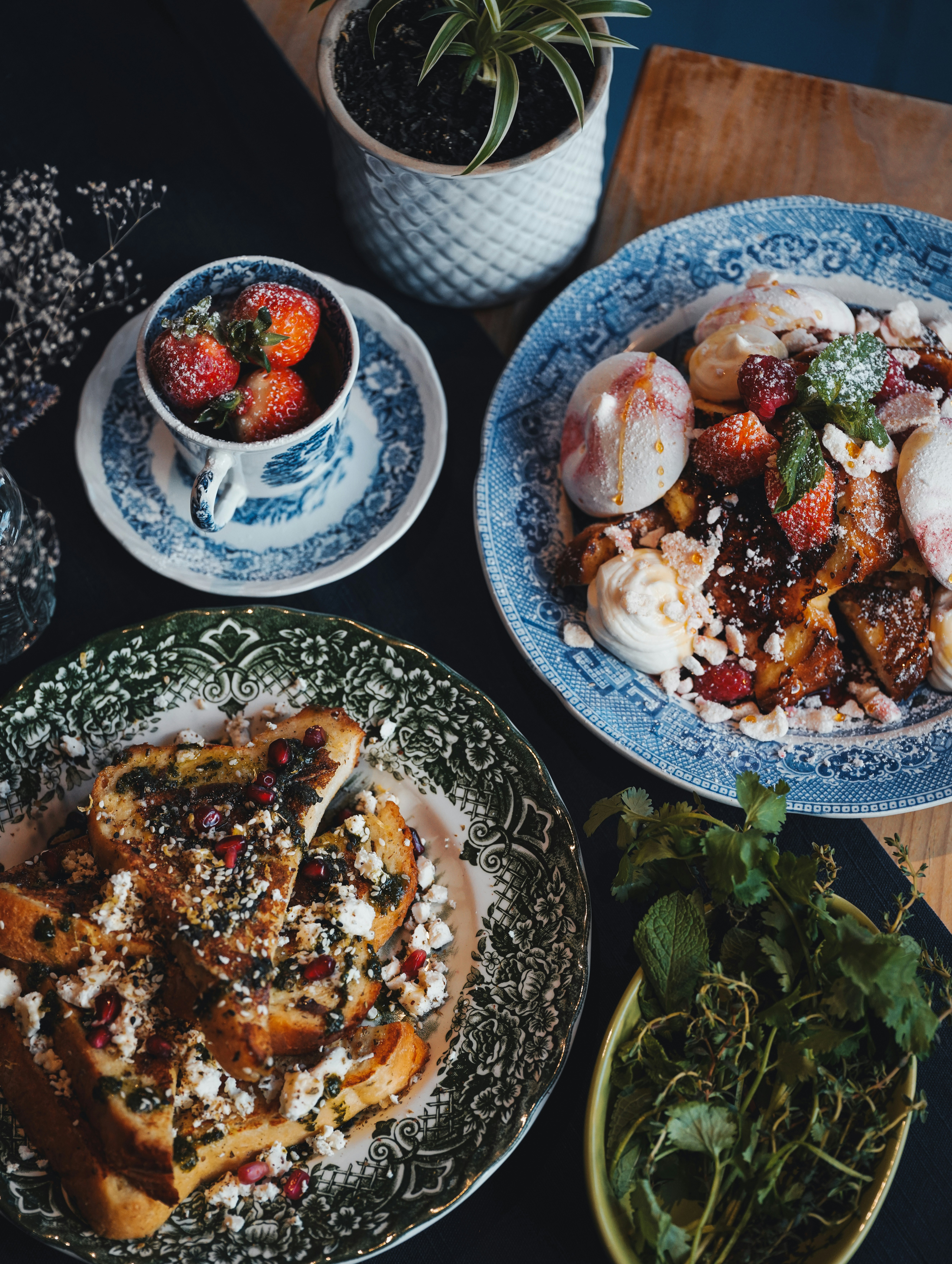 Two plates of french toast with fruit and ice cream.