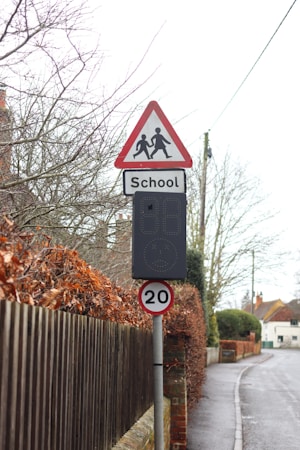 School zone sign with a digital speed indicator showing a reduced speed limit for drivers