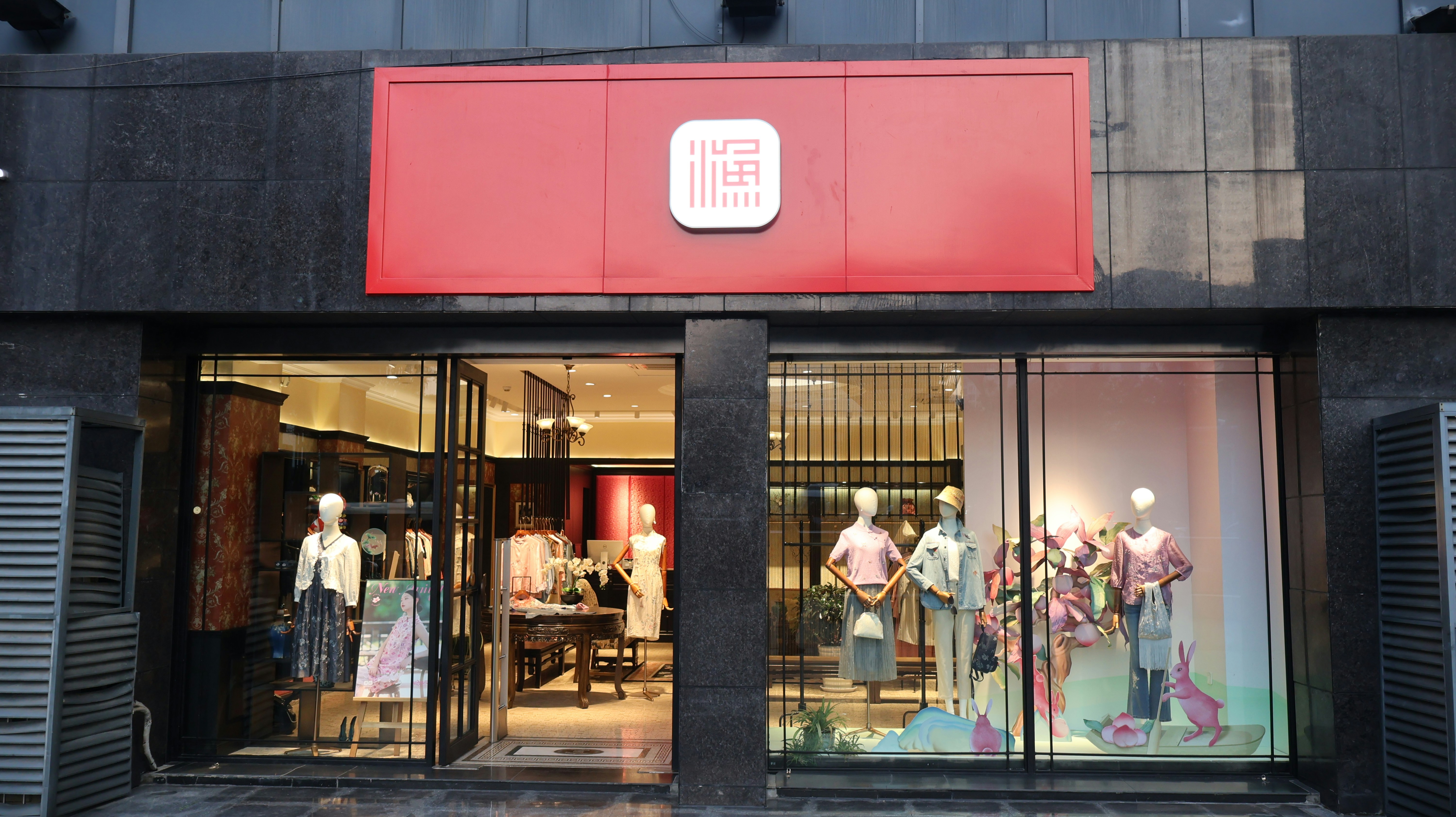 A clothing store storefront with mannequins displaying outfits.