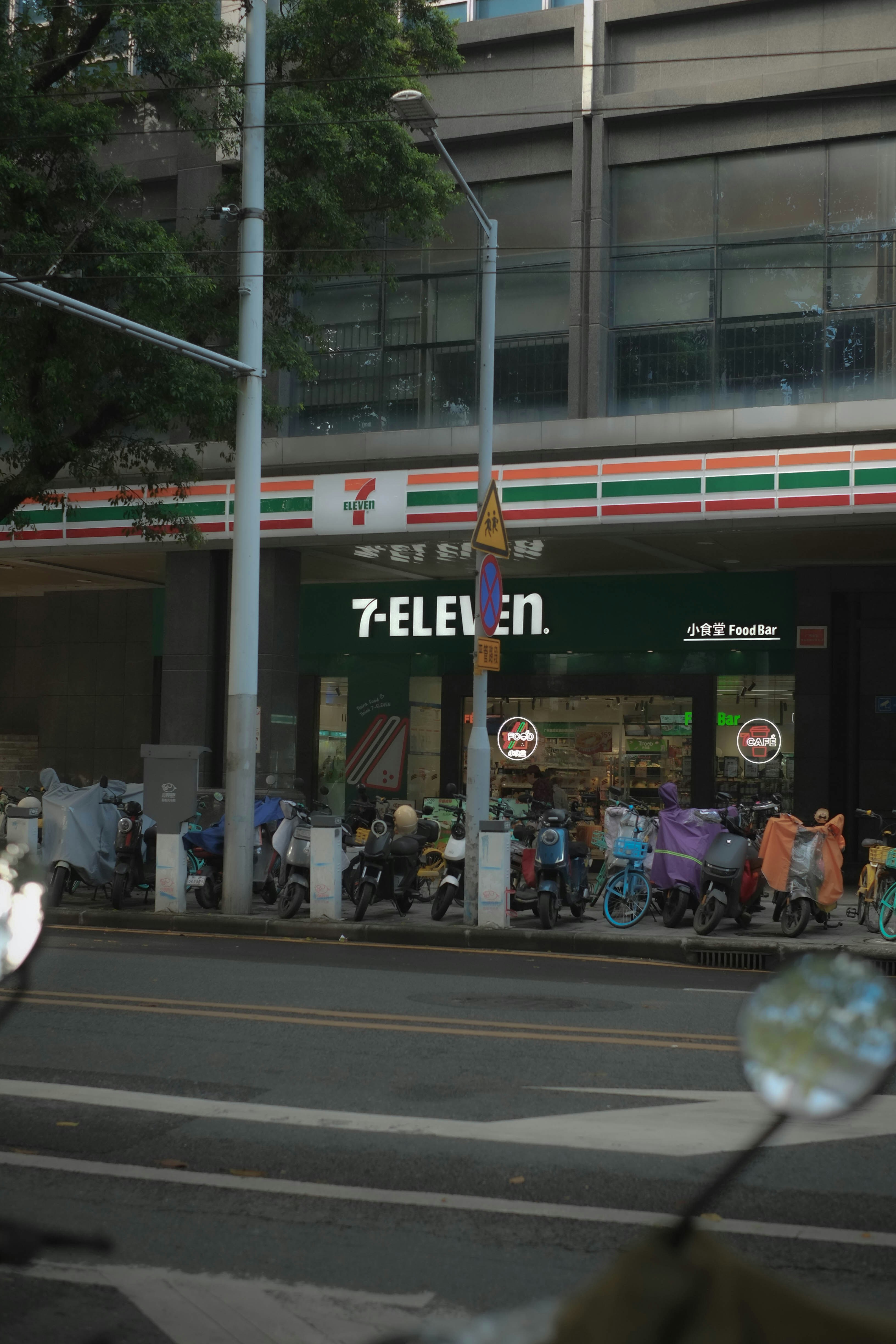 7-eleven store with parked scooters on street