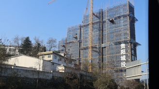 Building under construction with cranes and scaffolding