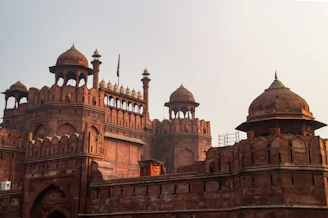 Red sandstone fort with domed towers and battlements