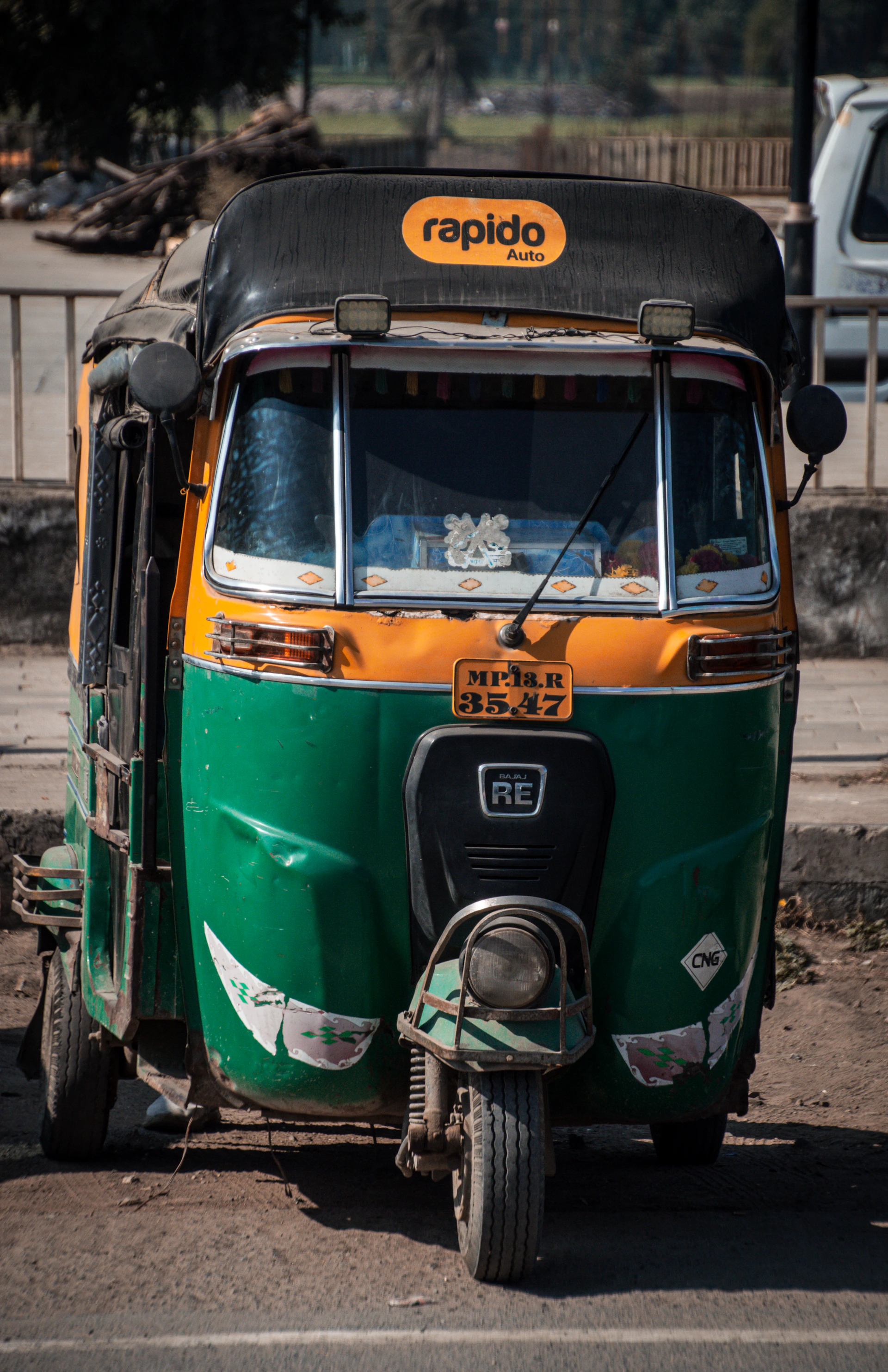A colorful auto-rickshaw with a rapido logo