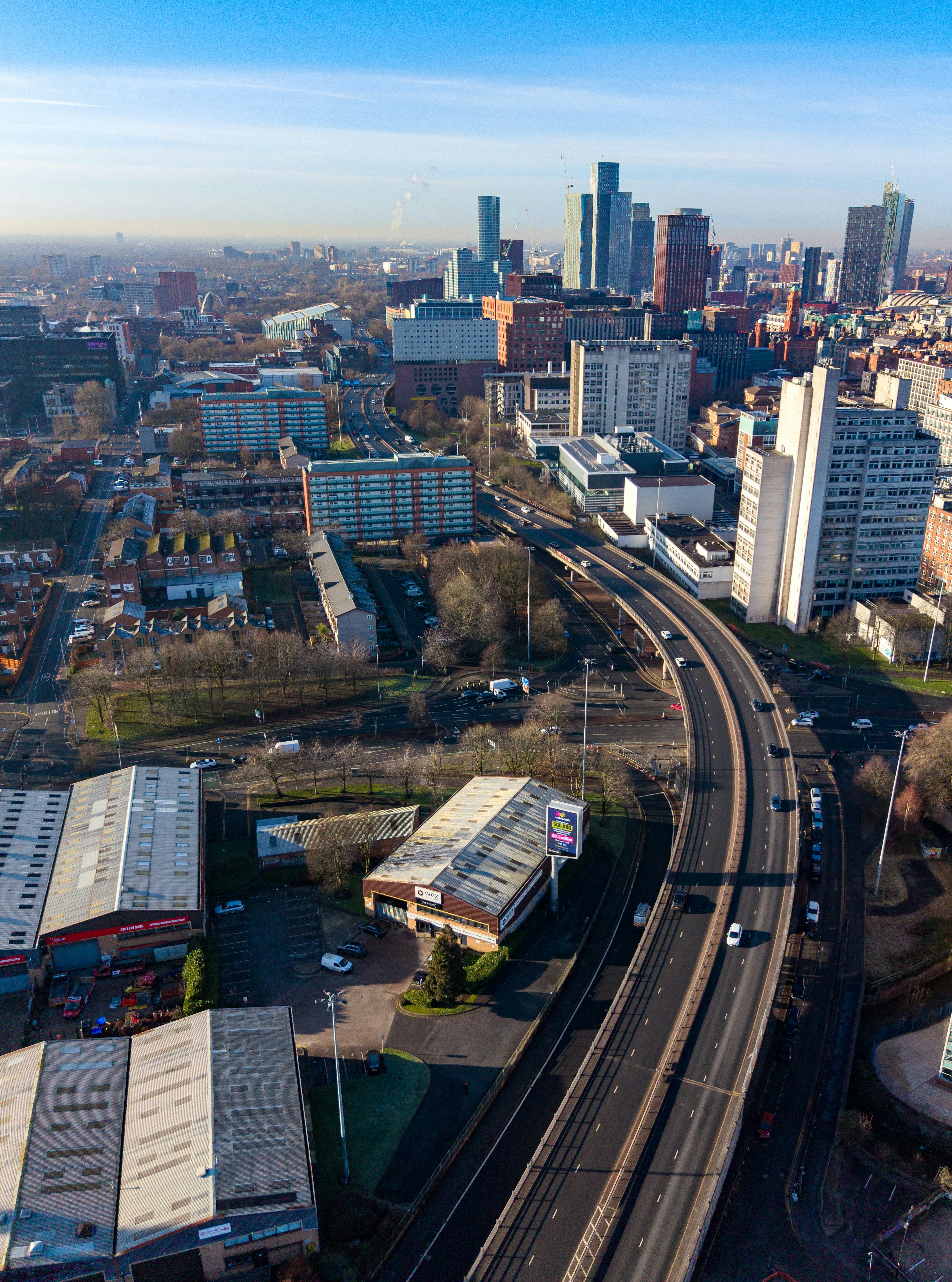 Luftaufnahme einer Stadt mit Autobahn und Wolkenkratzern.