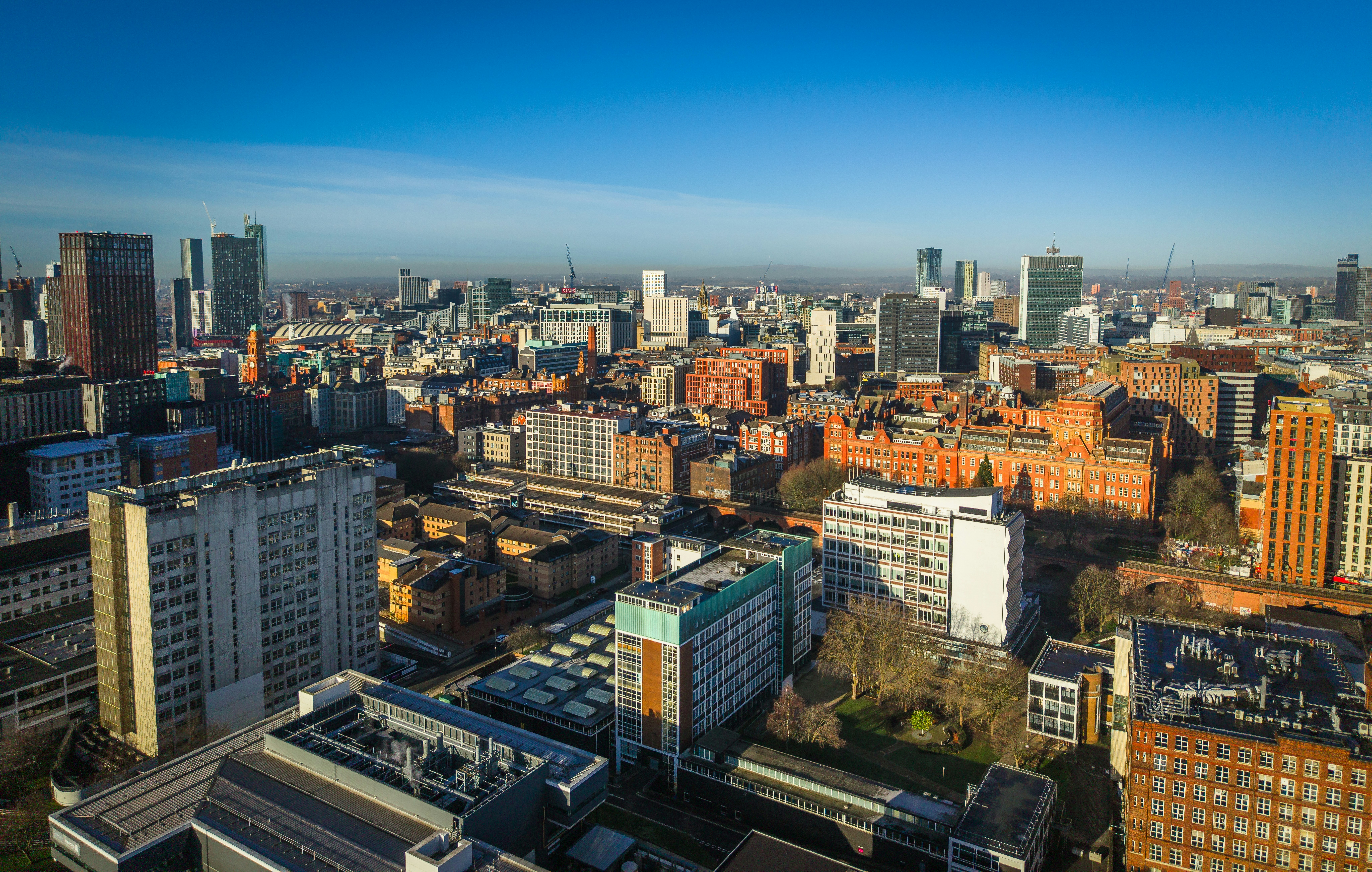 Luftaufnahme einer weitläufigen Stadtsilhouette mit modernen Gebäuden.