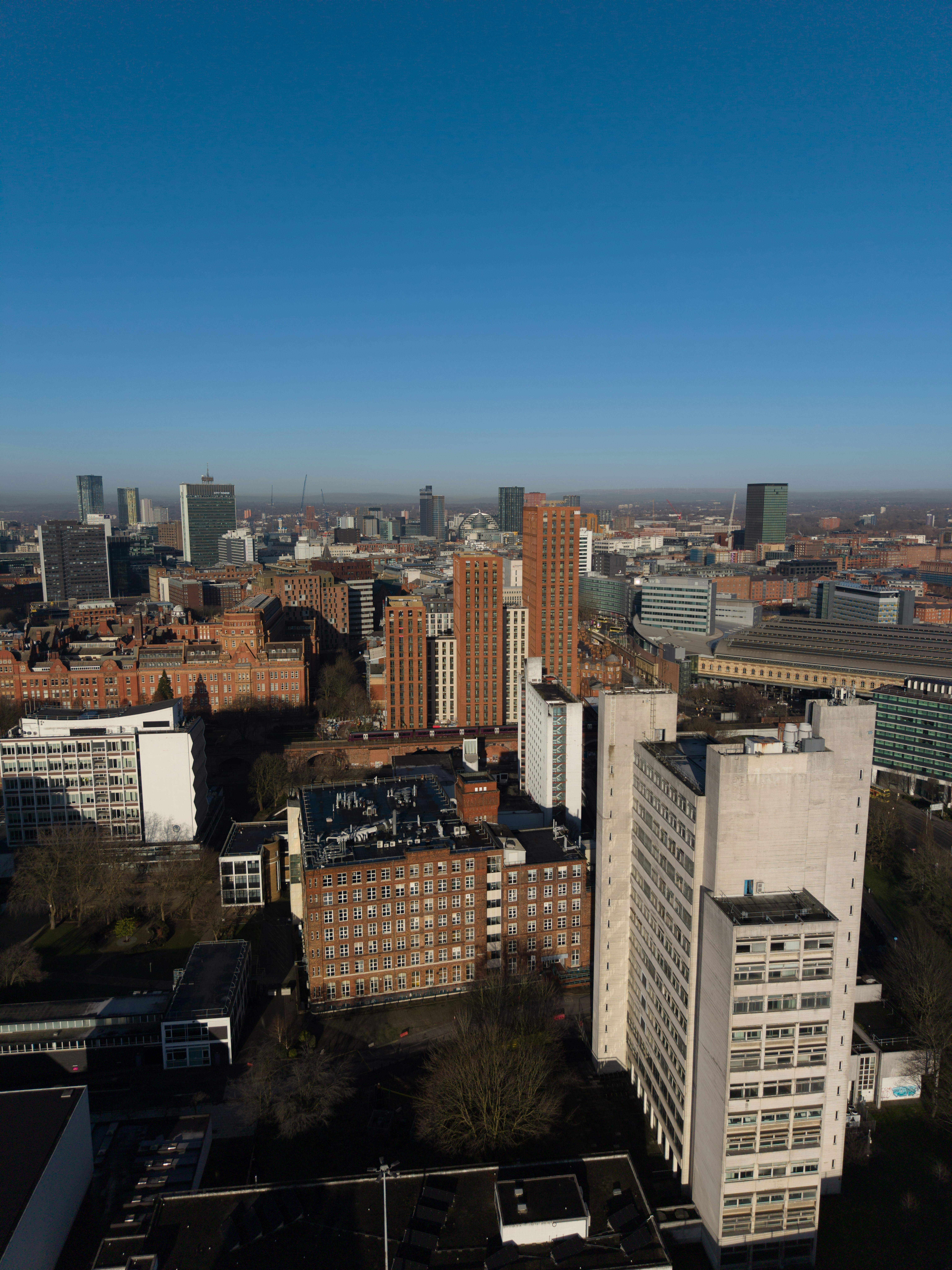 Eine weitläufige Stadtlandschaft mit hohen Gebäuden unter klarem Himmel.