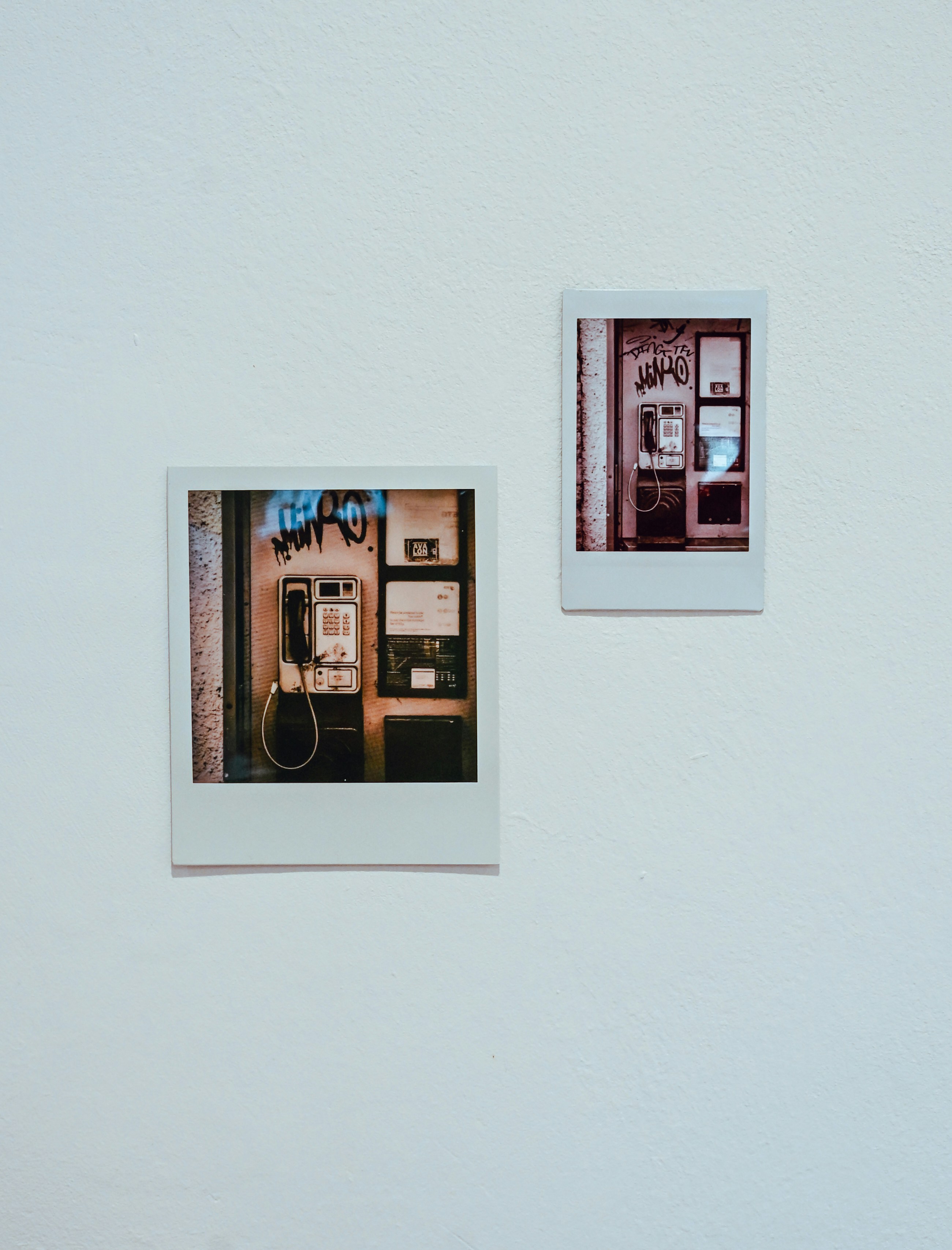 Two instant photos of vintage payphones on wall