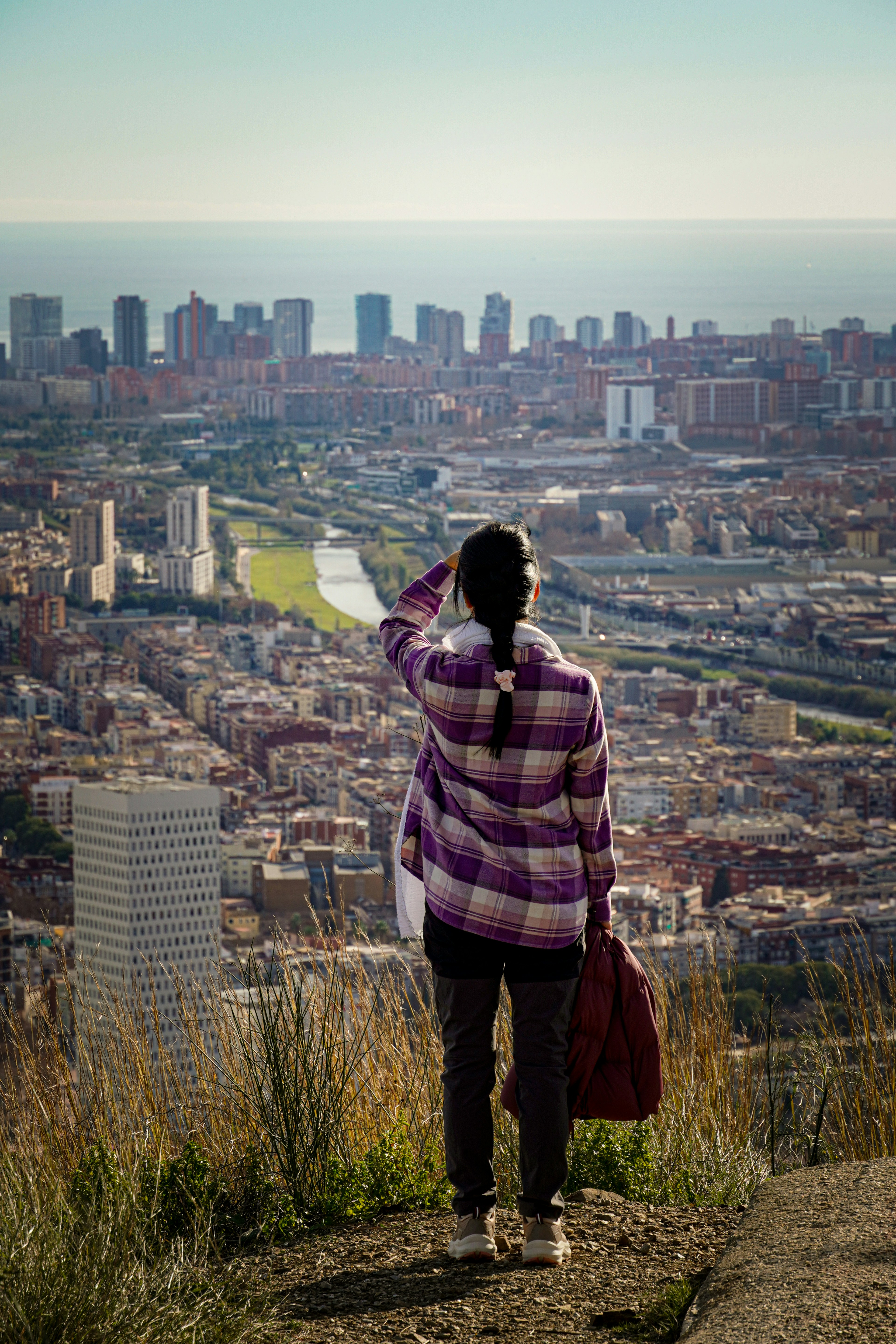 Woman looking at cityscape from a hill