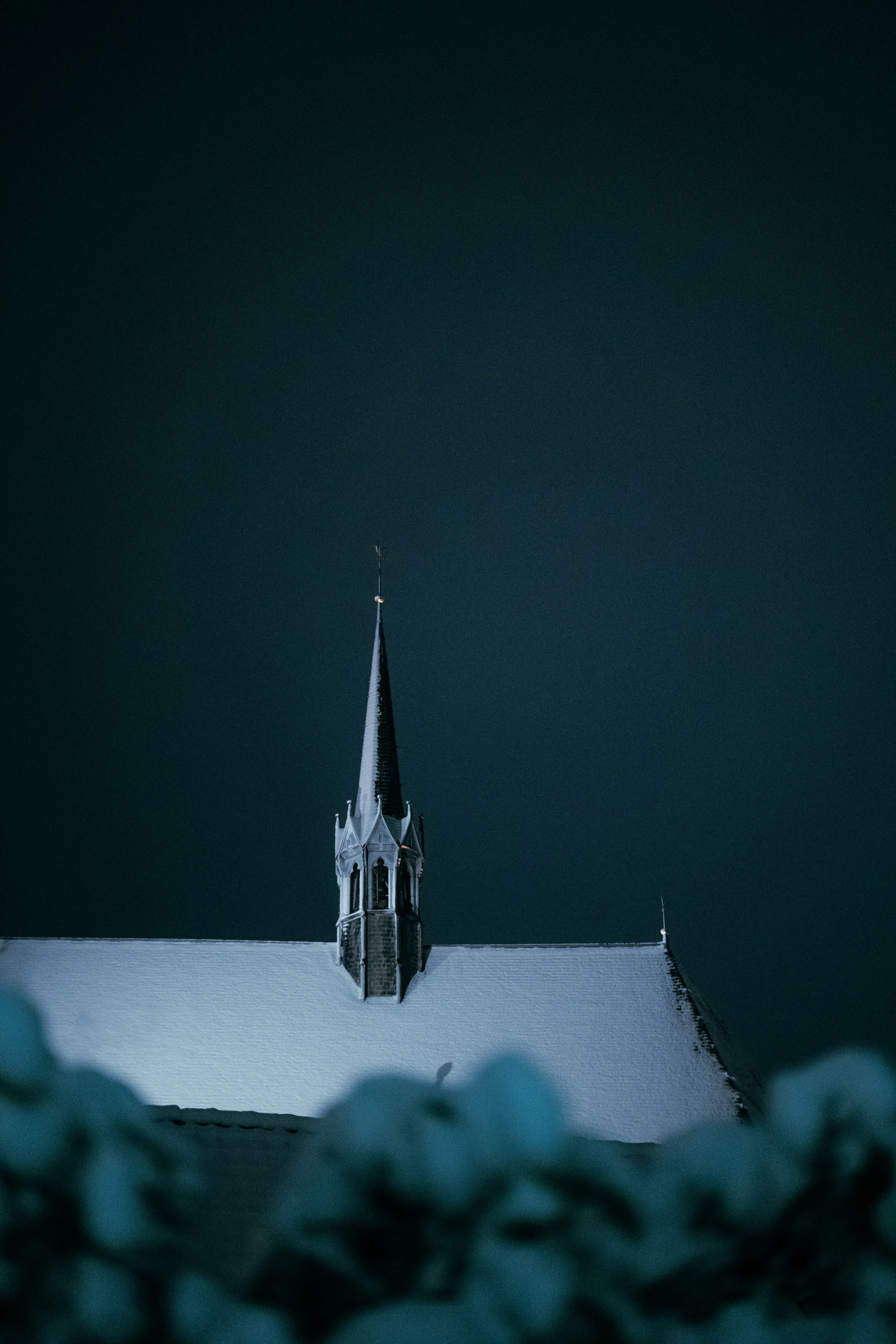 Snow covered church steeple against dark sky