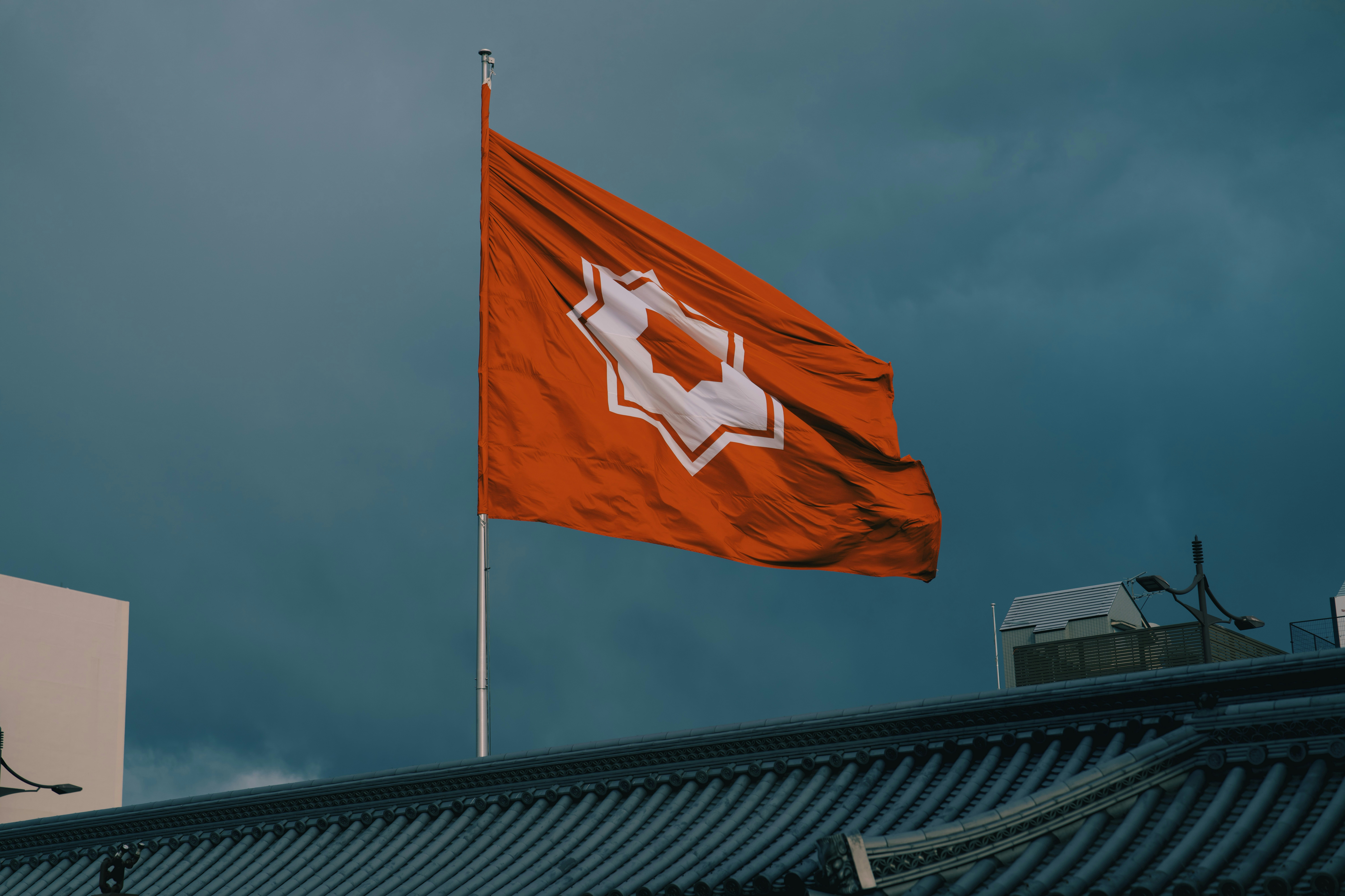 A red flag with a white emblem flies high.