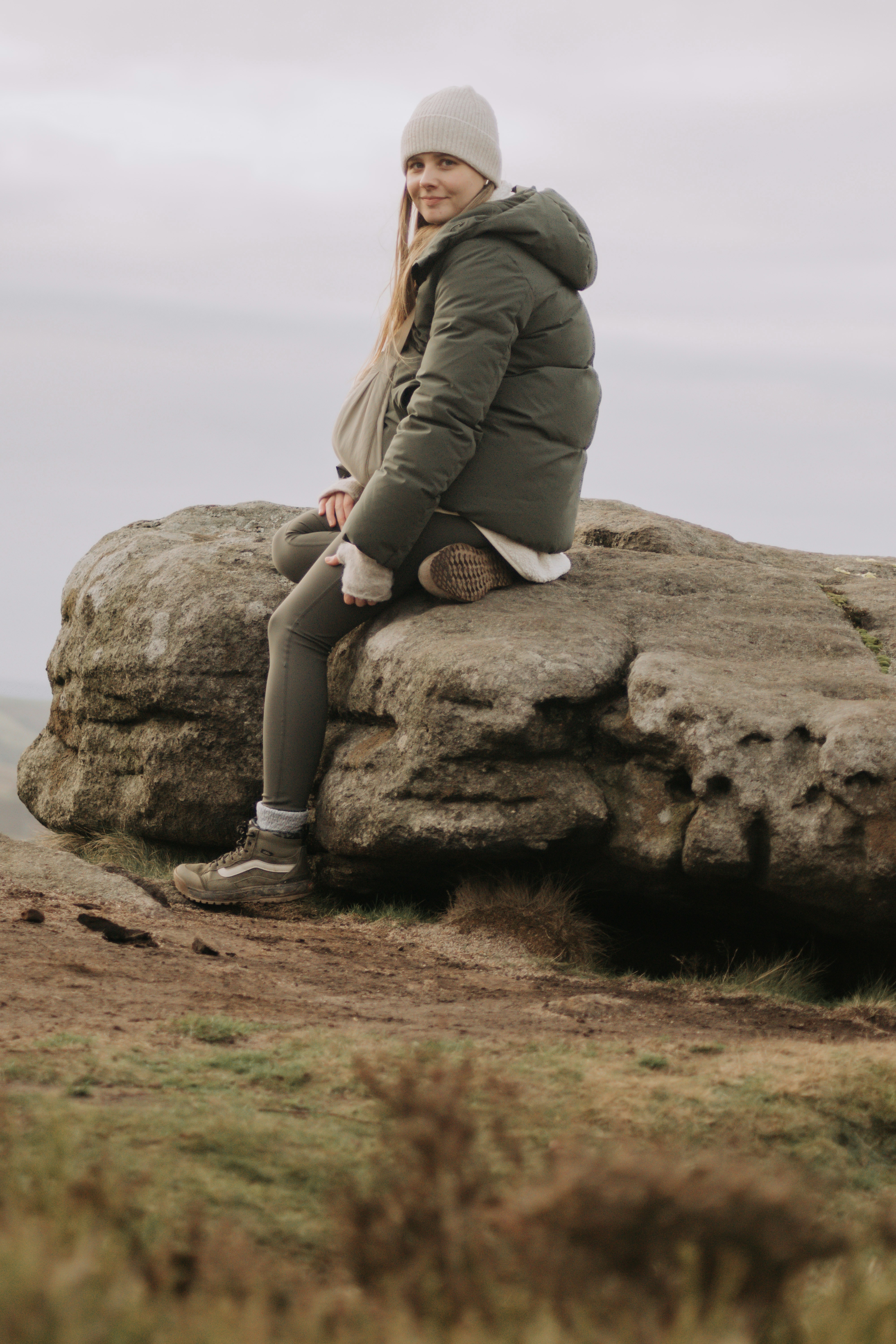 Woman sitting on a large rock outdoors