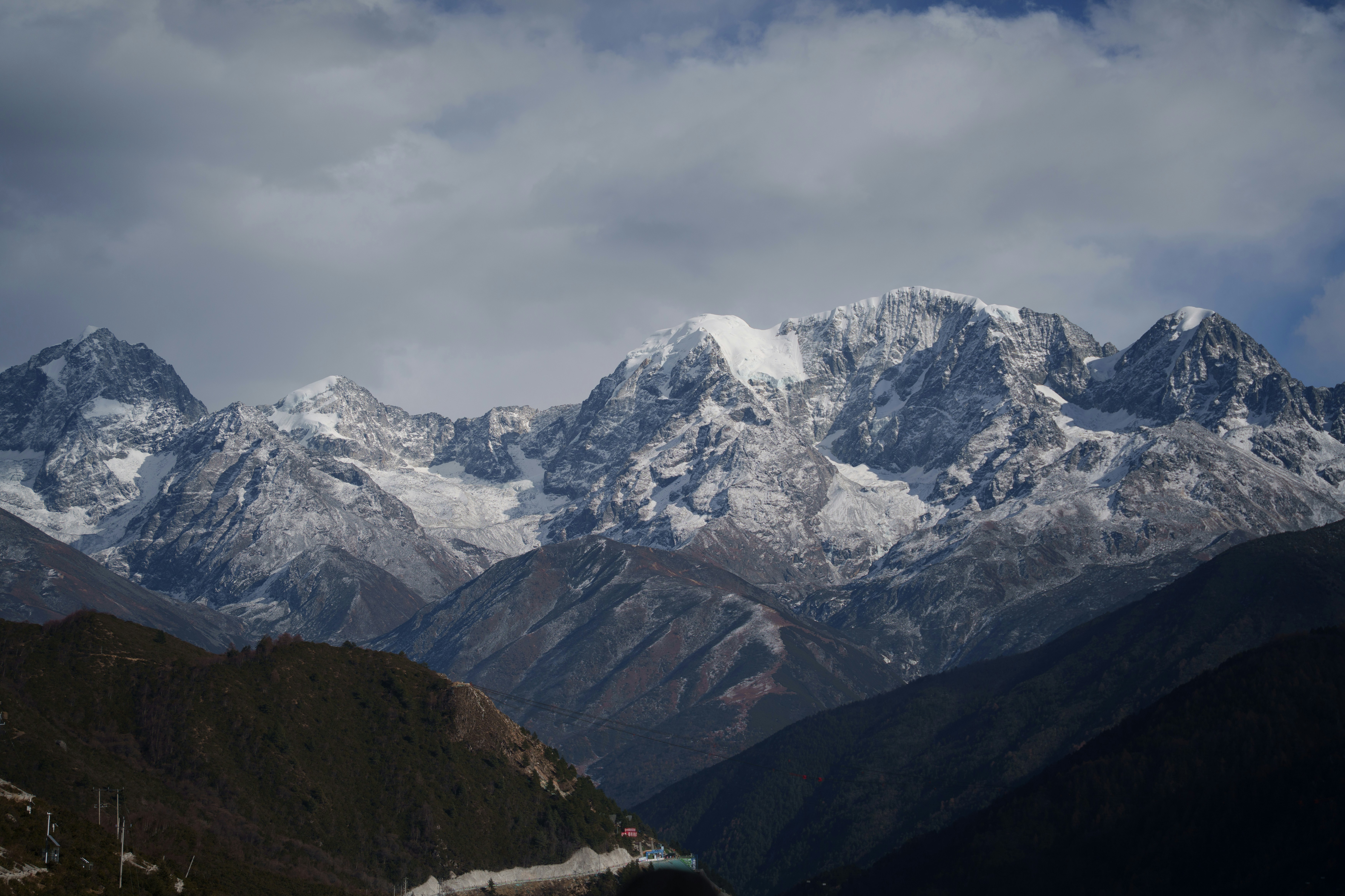 Snow-capped mountains under a cloudy sky