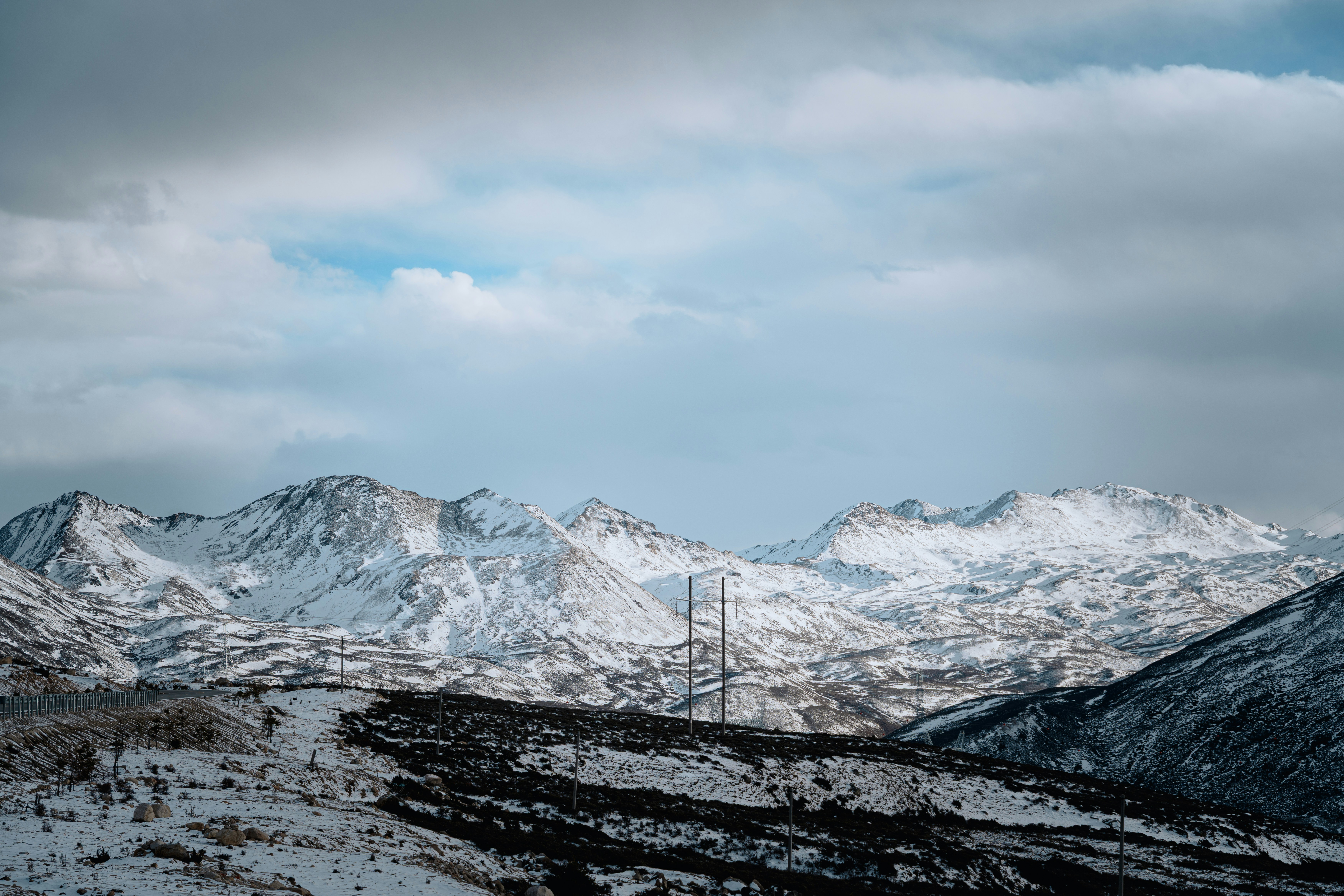 Snow-covered mountains under a cloudy sky.
