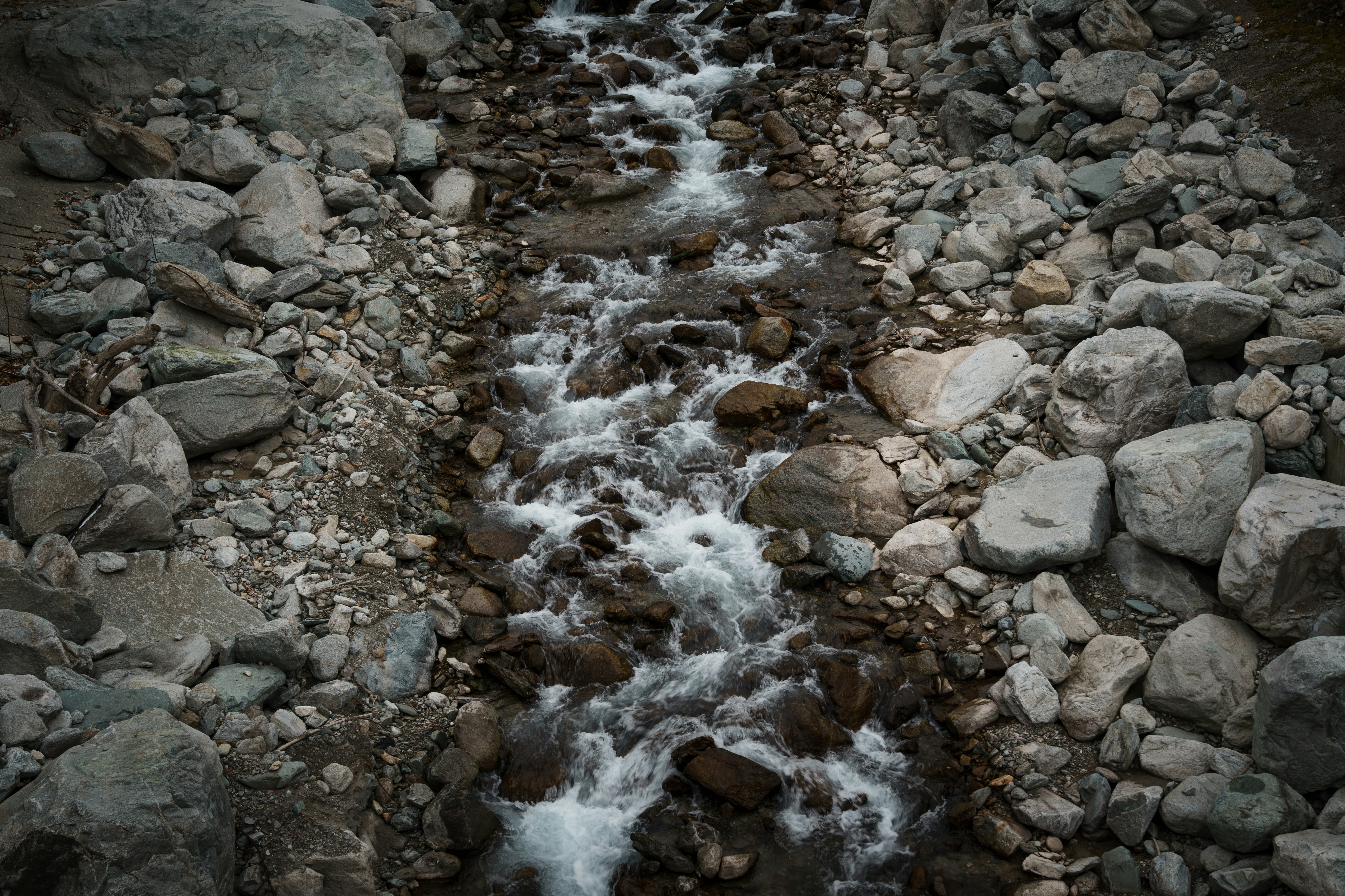 A rocky stream flows downhill through a stony landscape.
