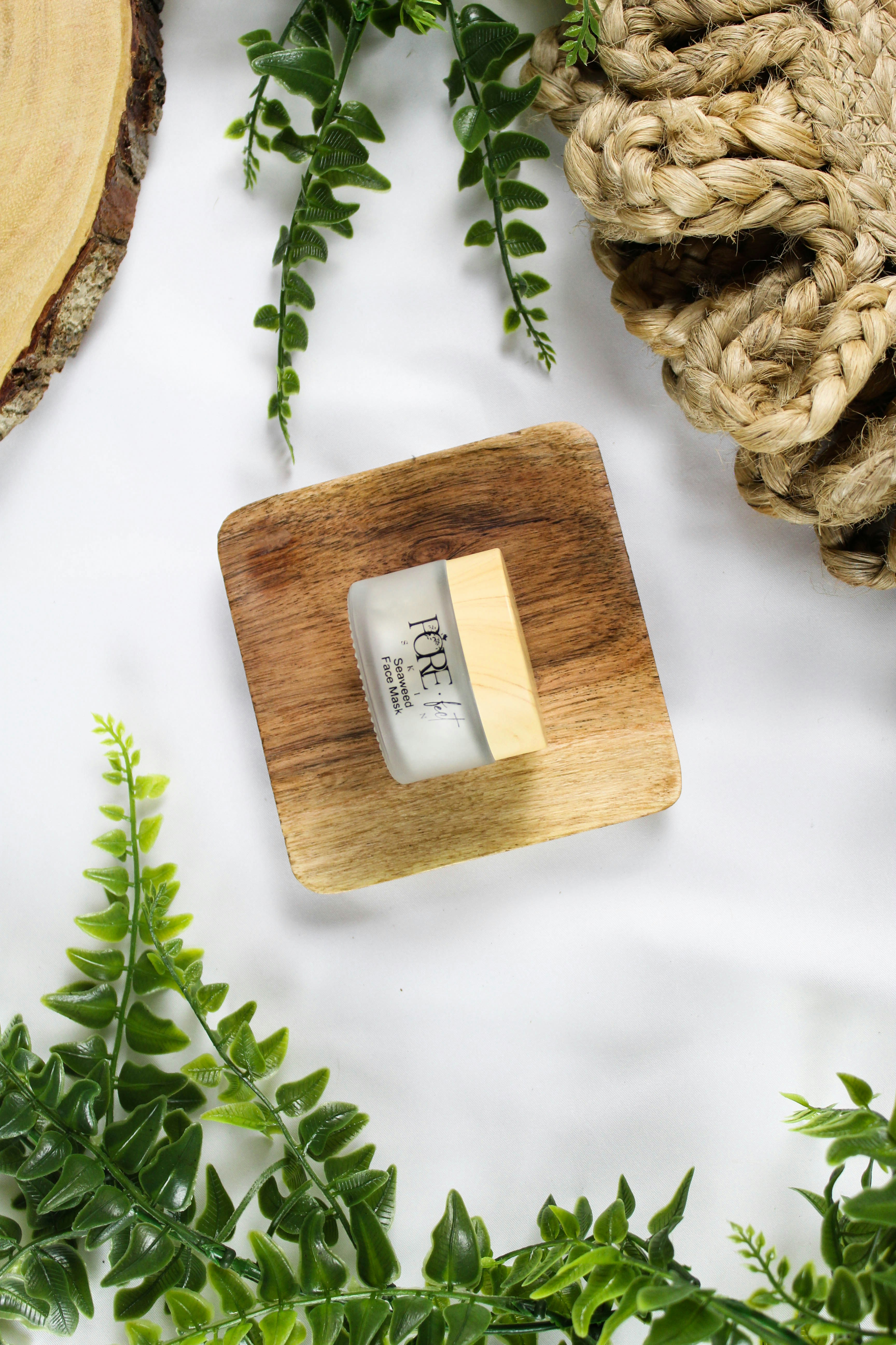 Ein kleines Glas Sahne auf einem Holzquadrat.