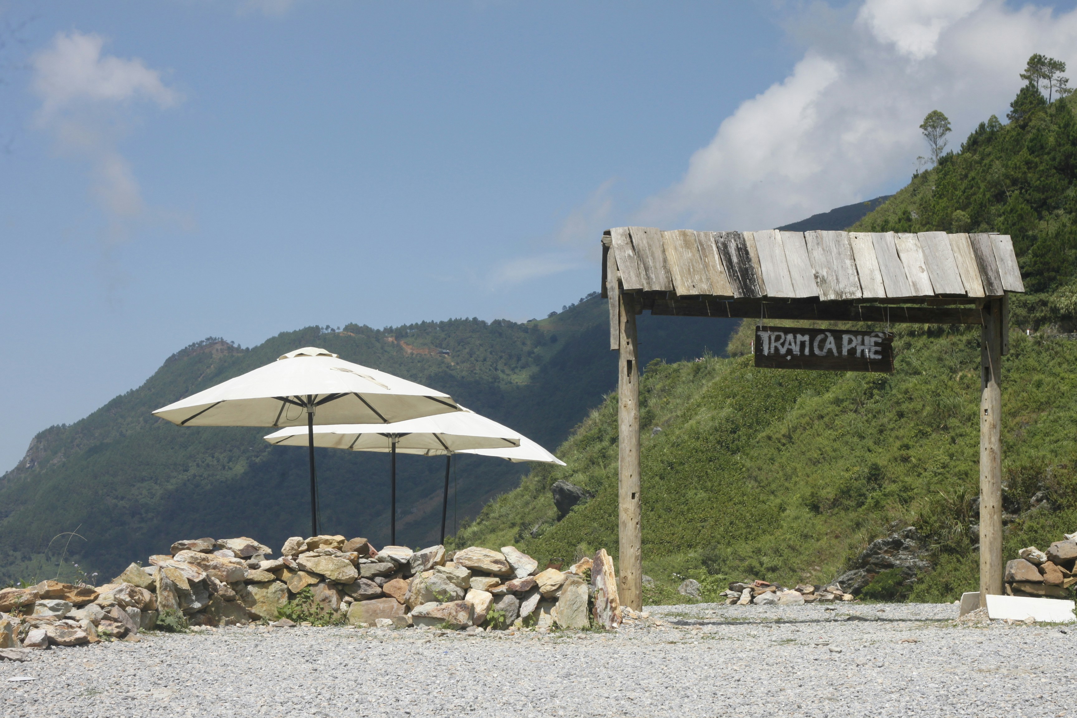 Wooden archway with sign overlooks green mountains