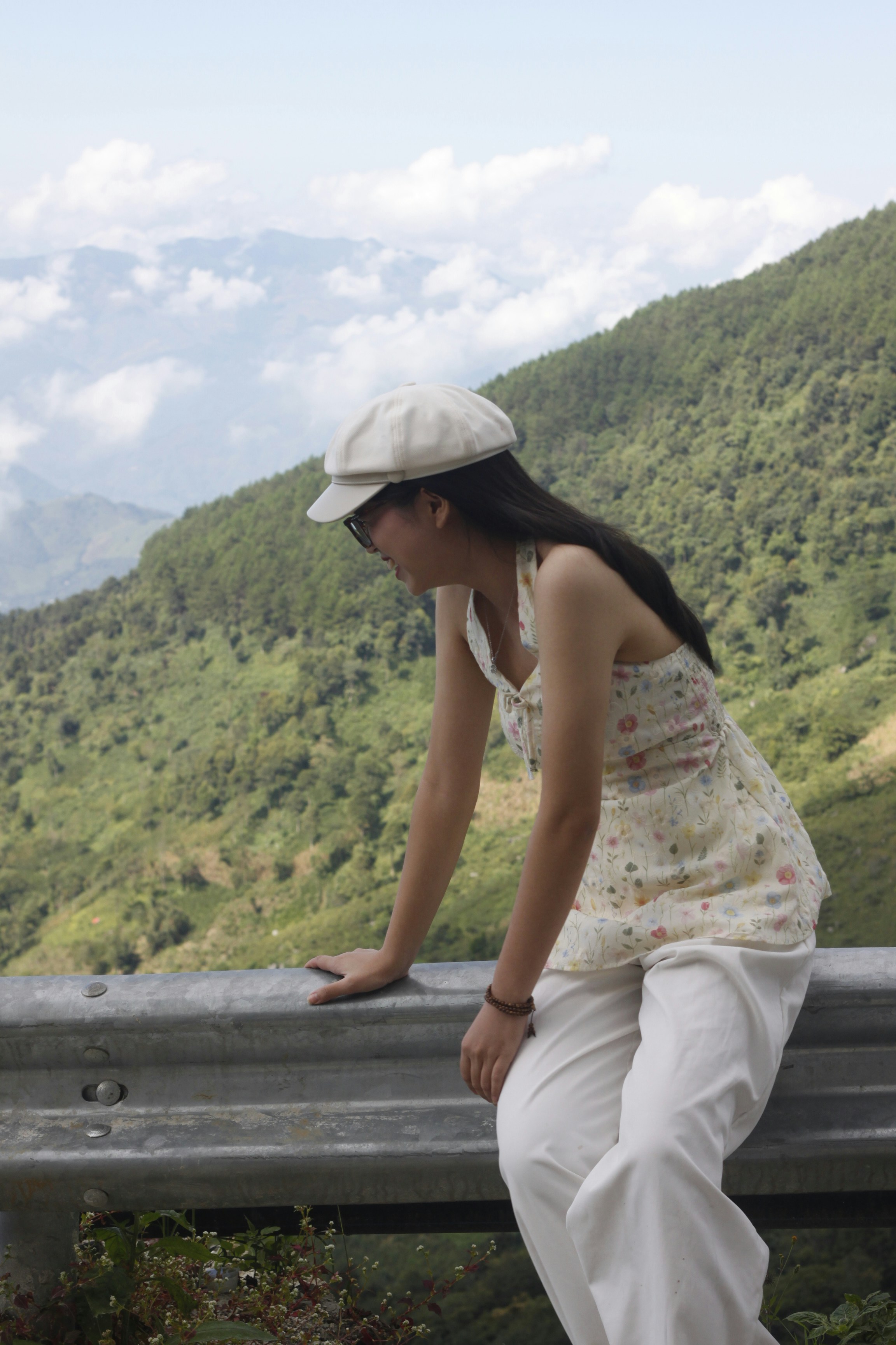 Woman in hat looking at green mountains