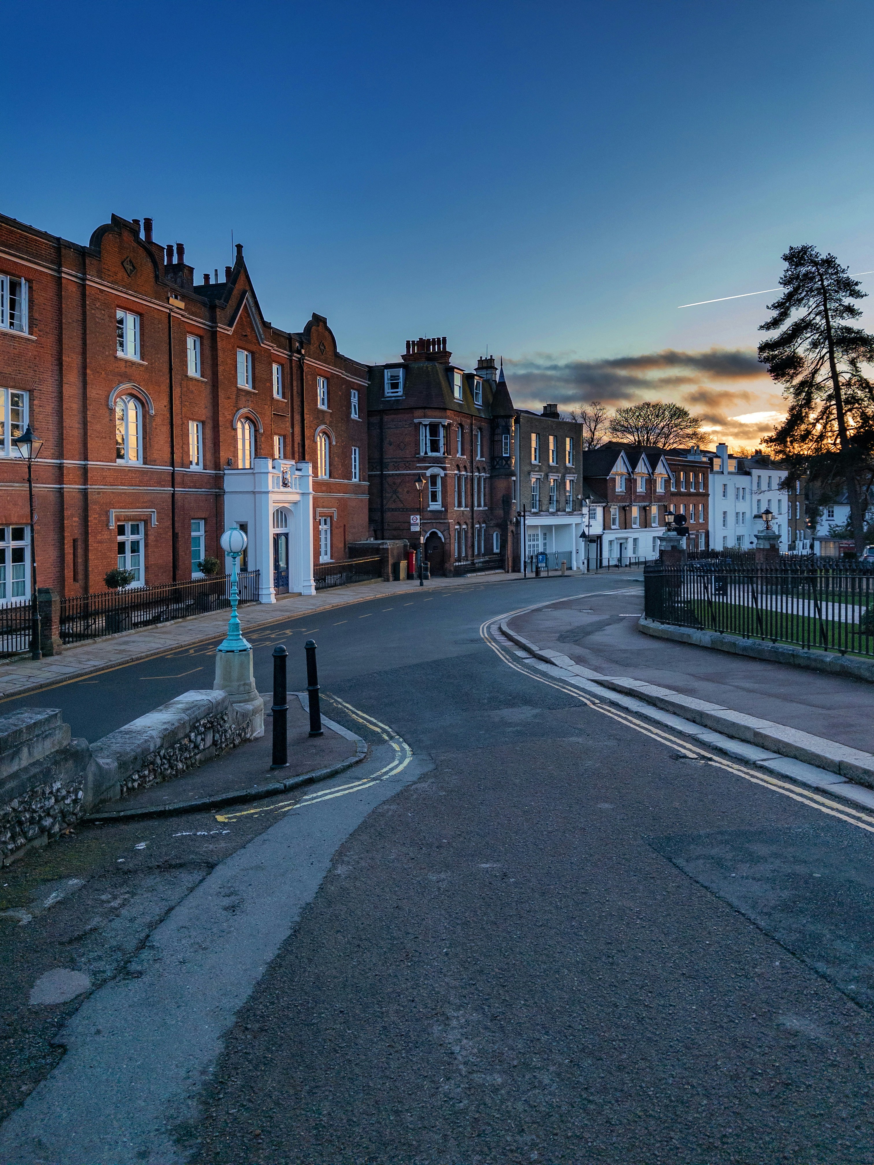 Street view of brick buildings at dusk with sunset sky.