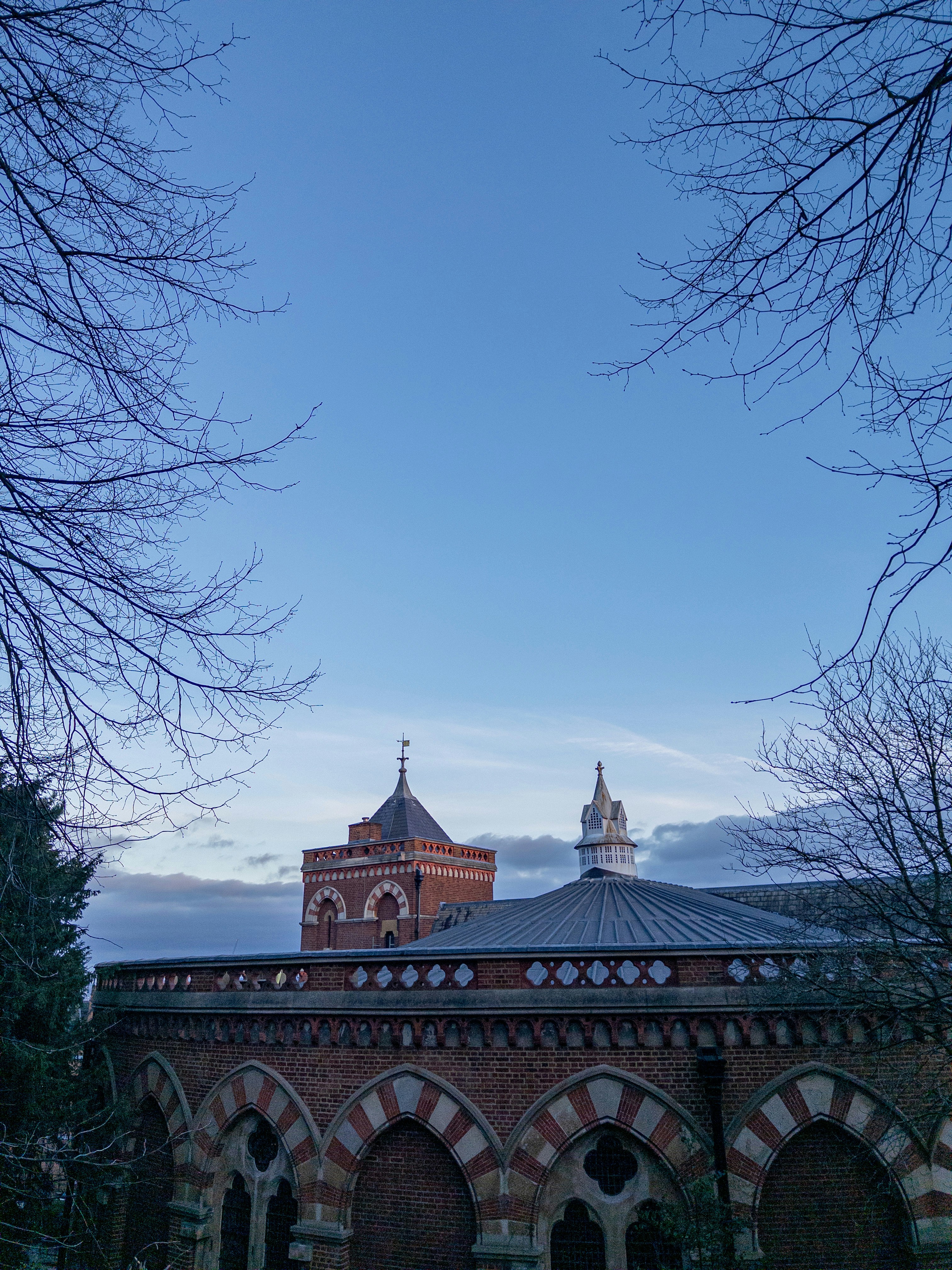 Brick building with arched windows and towers under sky
