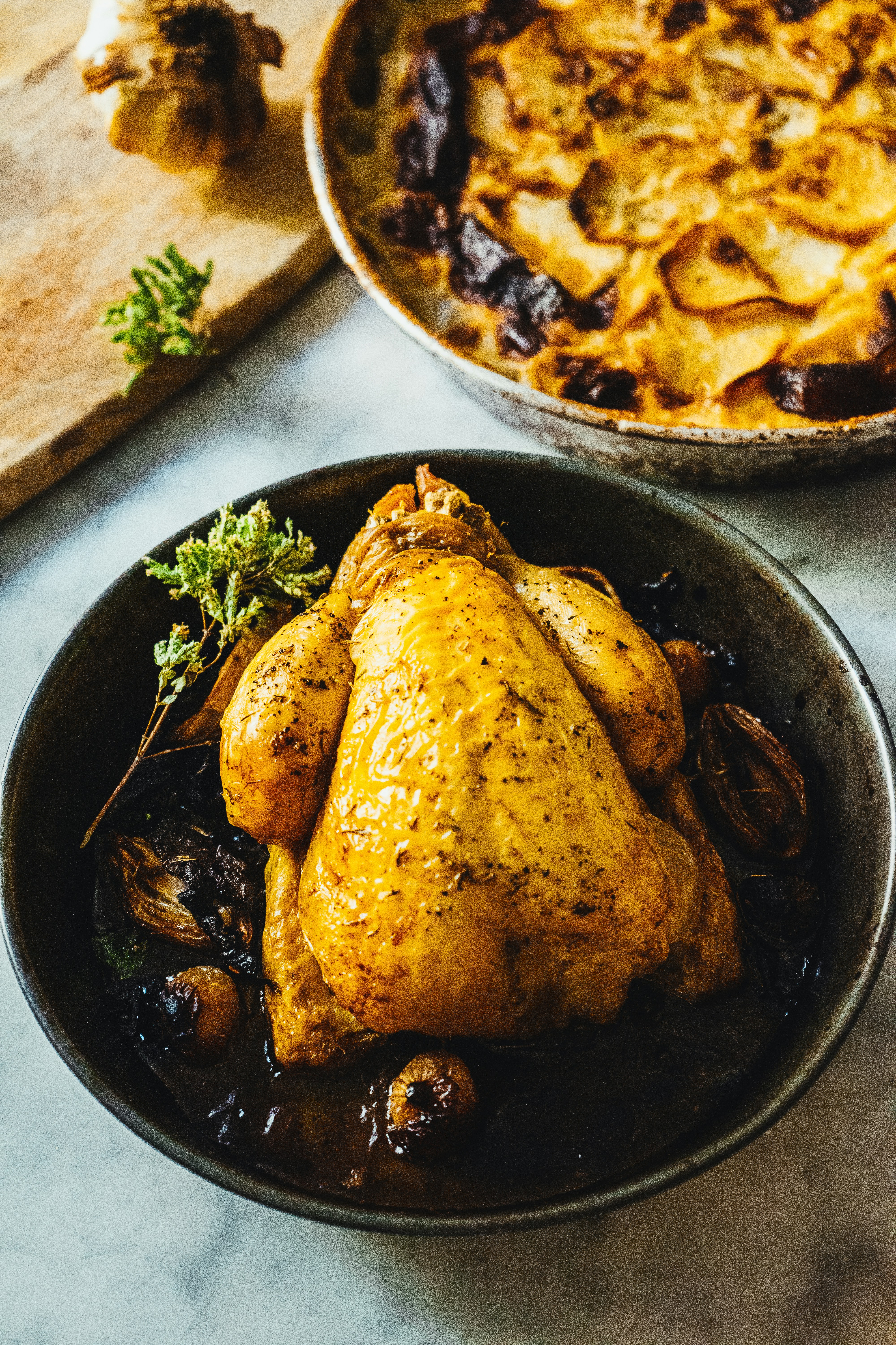 Poulet rôti avec des herbes et des légumes dans une poêle.