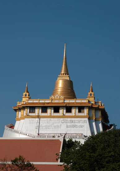 Golden temple spire against a clear blue sky