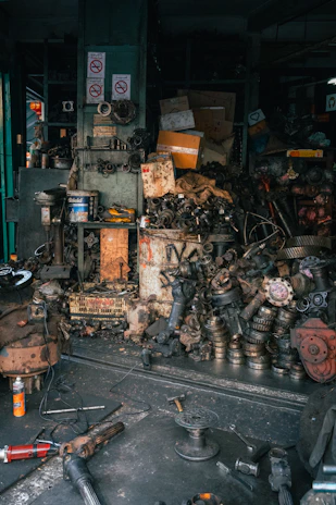 Jumbled pile of automotive parts in a cluttered workshop.