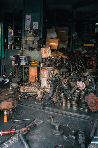 Jumbled pile of automotive parts in a cluttered workshop.