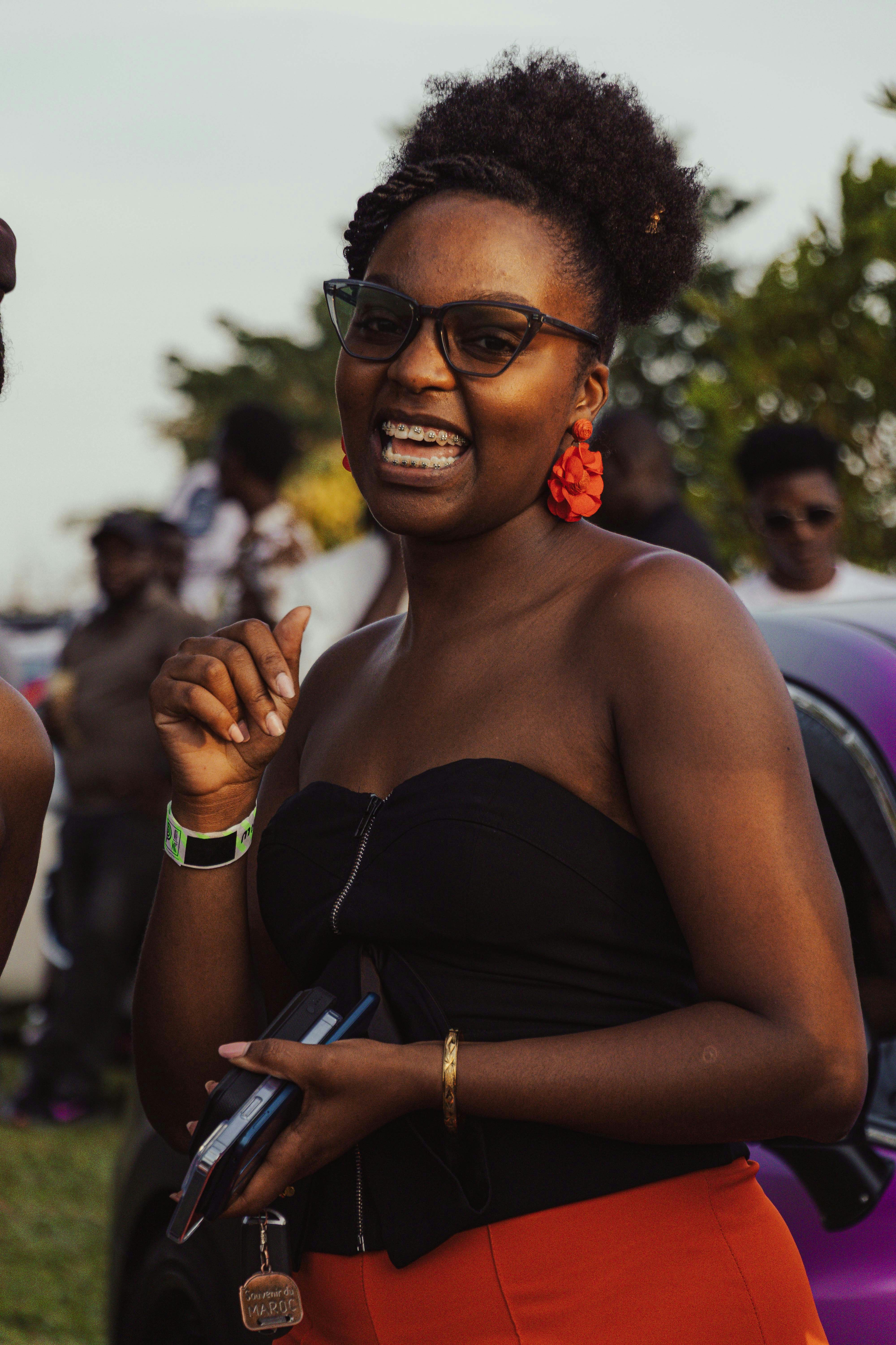 A black woman with glasses and red earrings smiles