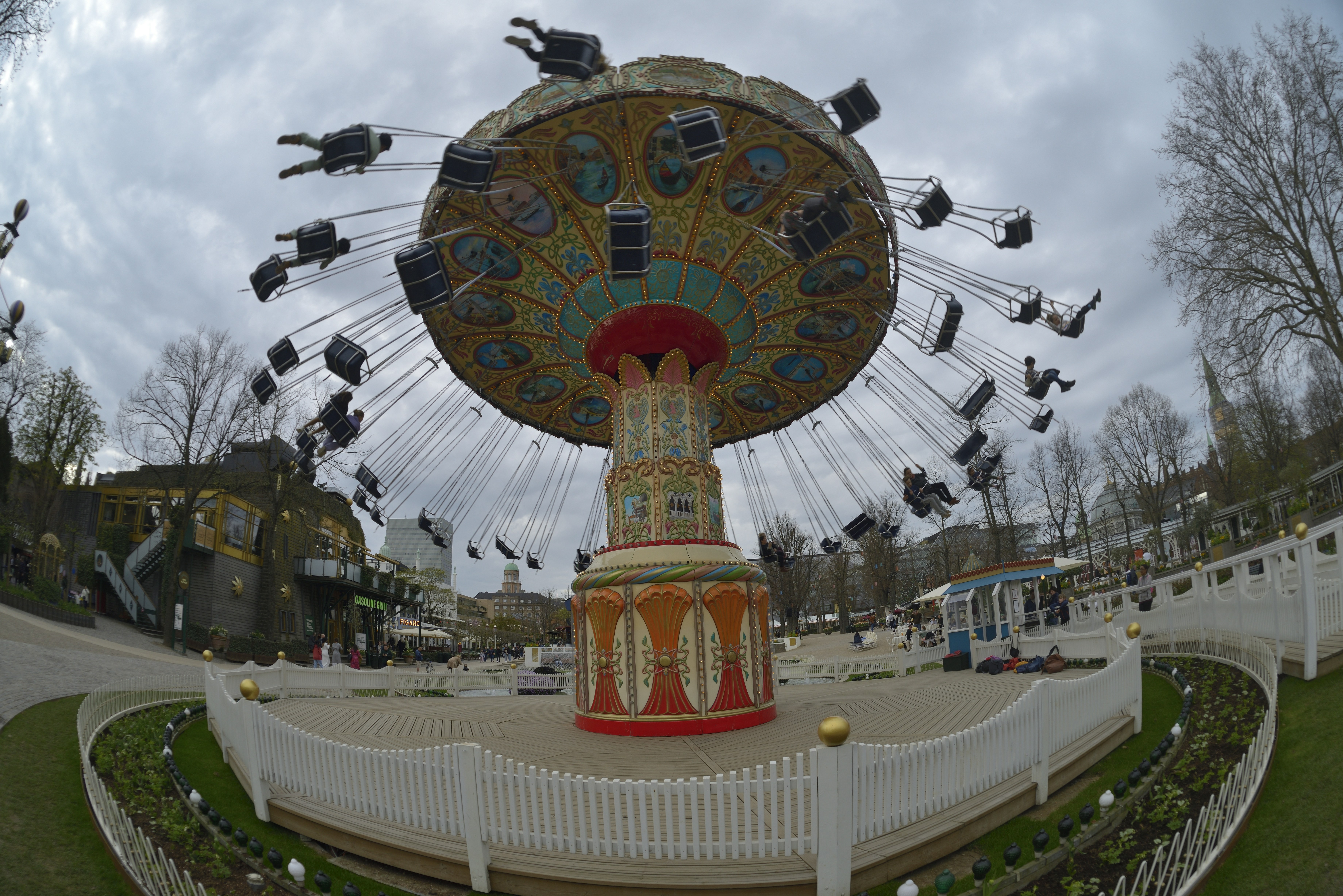 People ride a colorful swing carousel at an amusement park