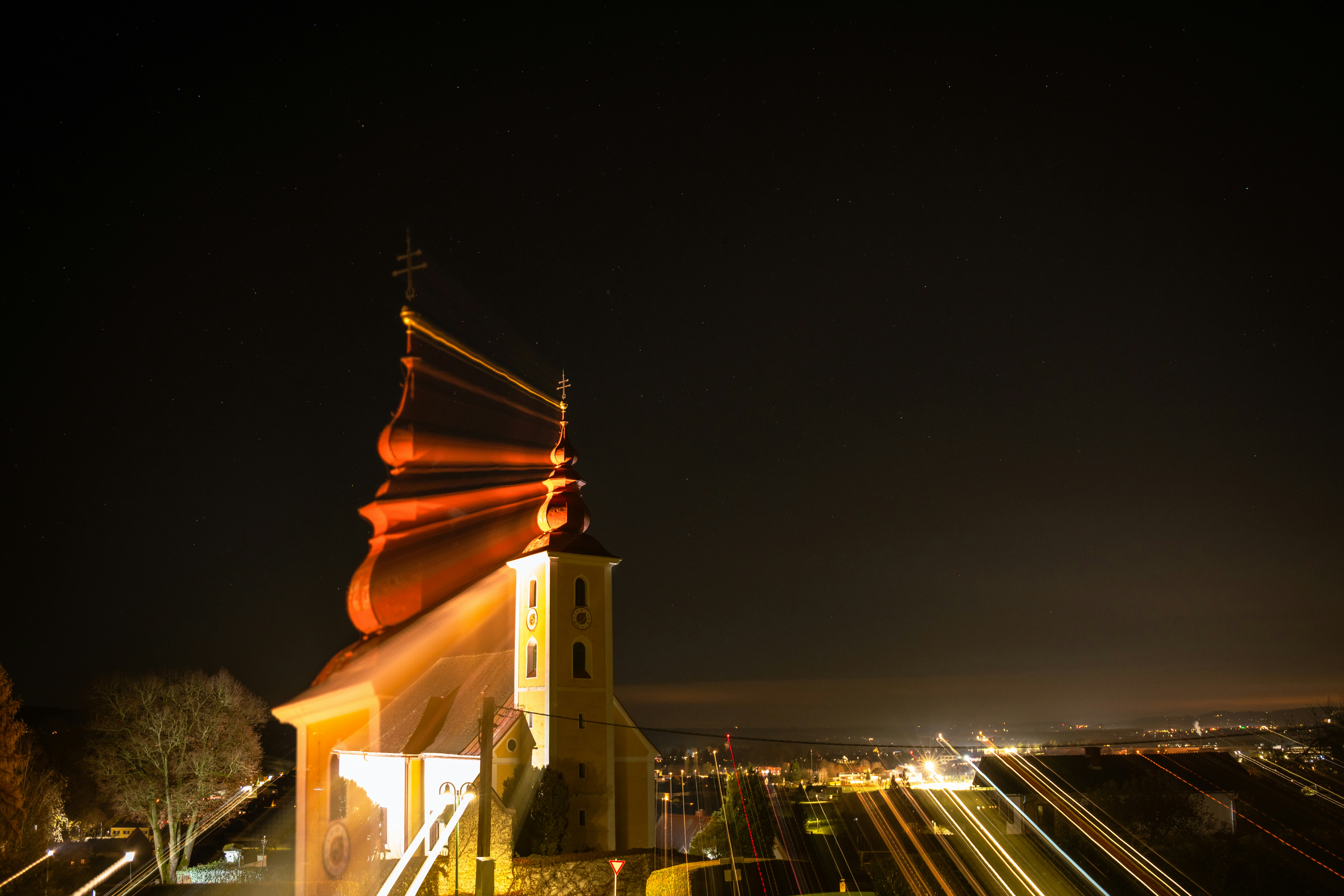 Torre de iglesia iluminada contra un cielo estrellado