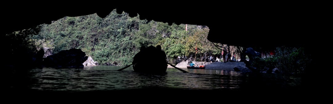 Rescuers in boats with searchlights looking for survivors in a river at night, with debris of a collapsed bridge visible in the background.