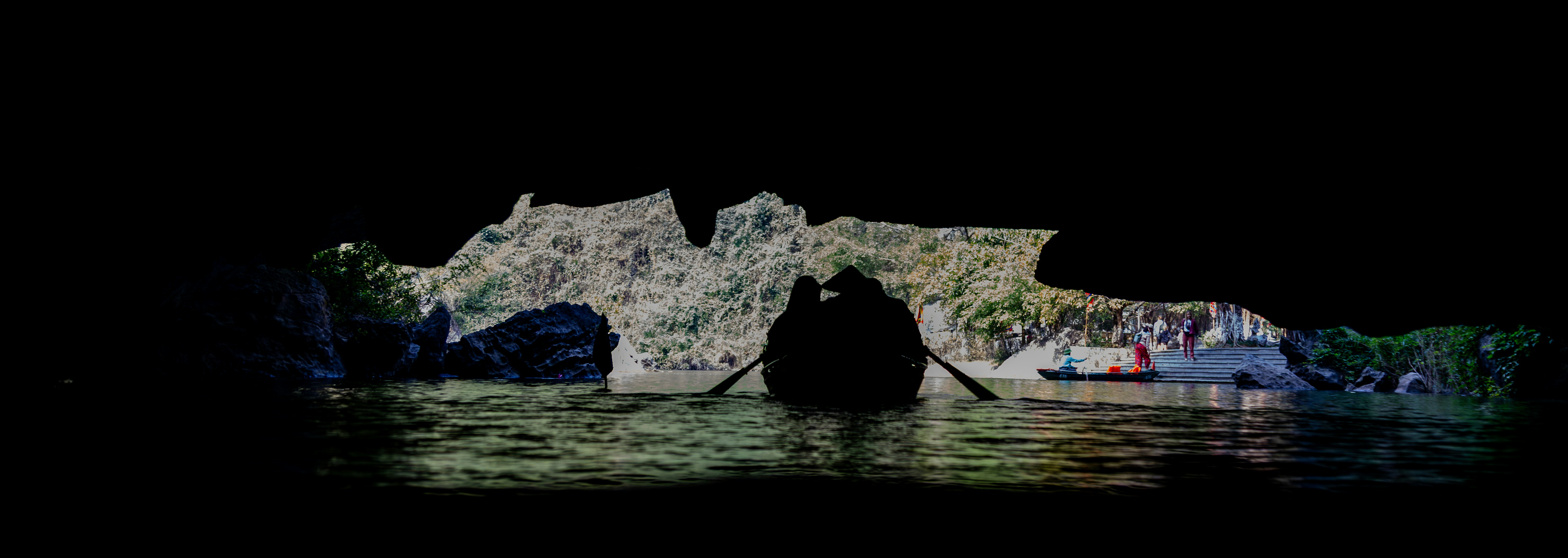 Persona che rema una barca attraverso una grotta buia