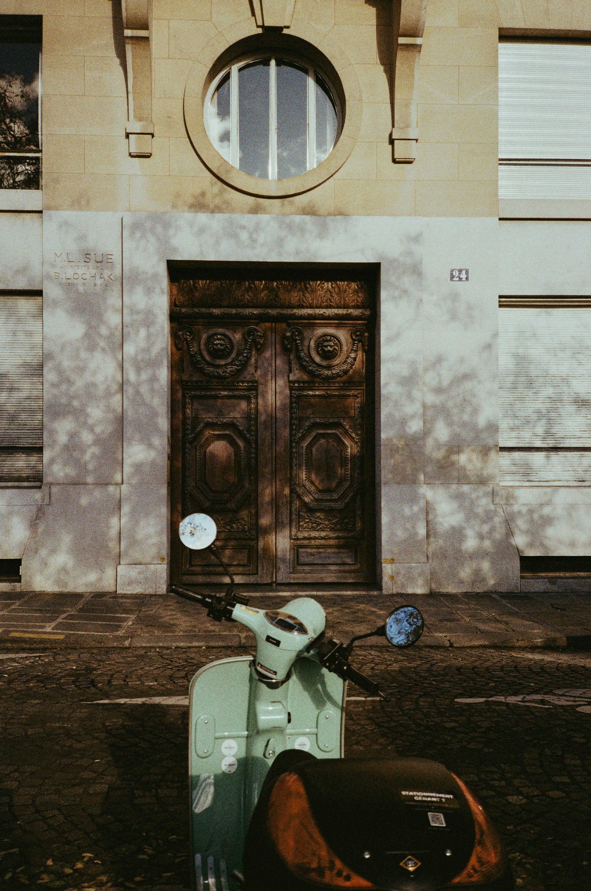 A mint green scooter parked outside a building