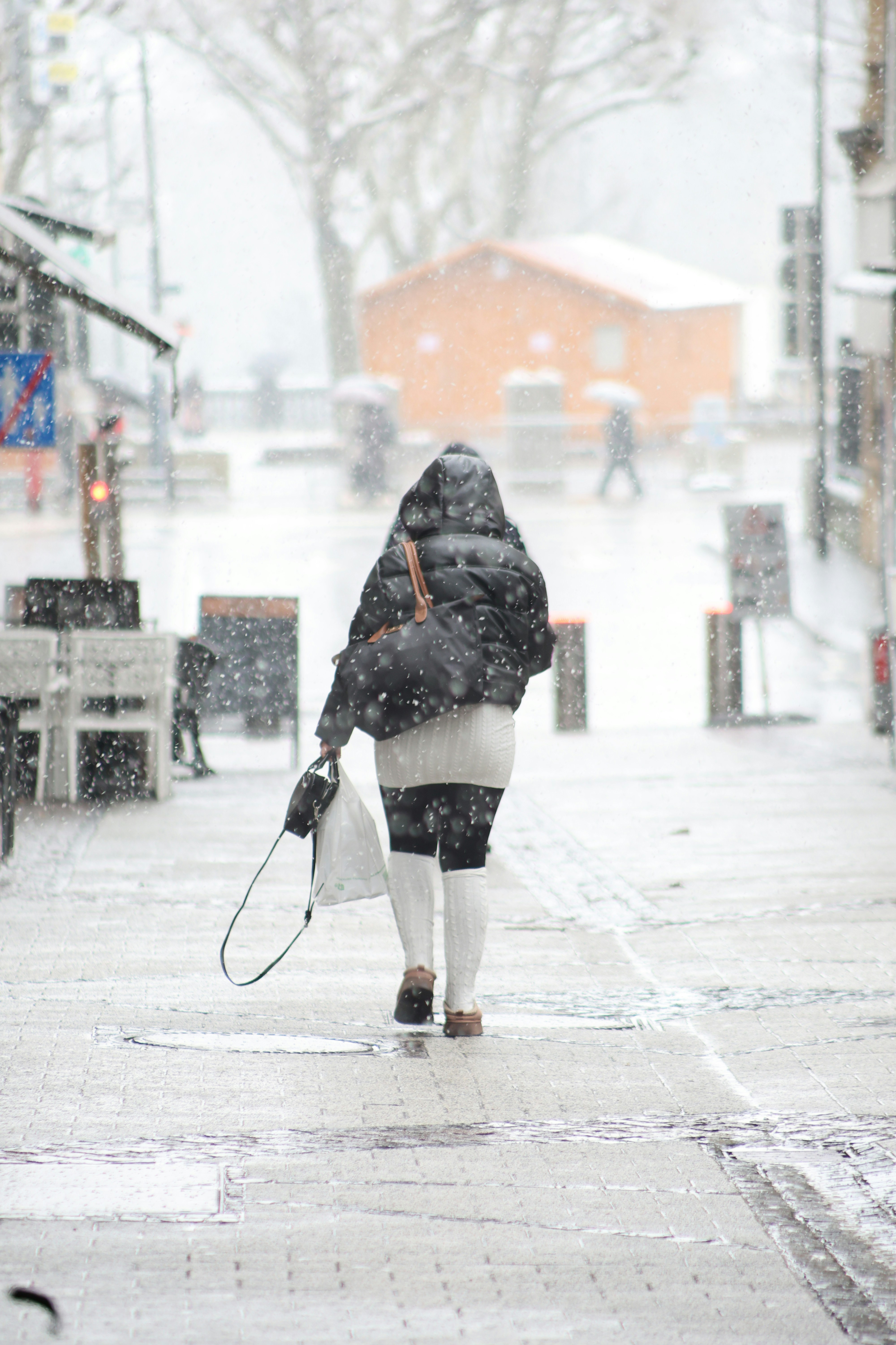 A person walks down a snowy street.