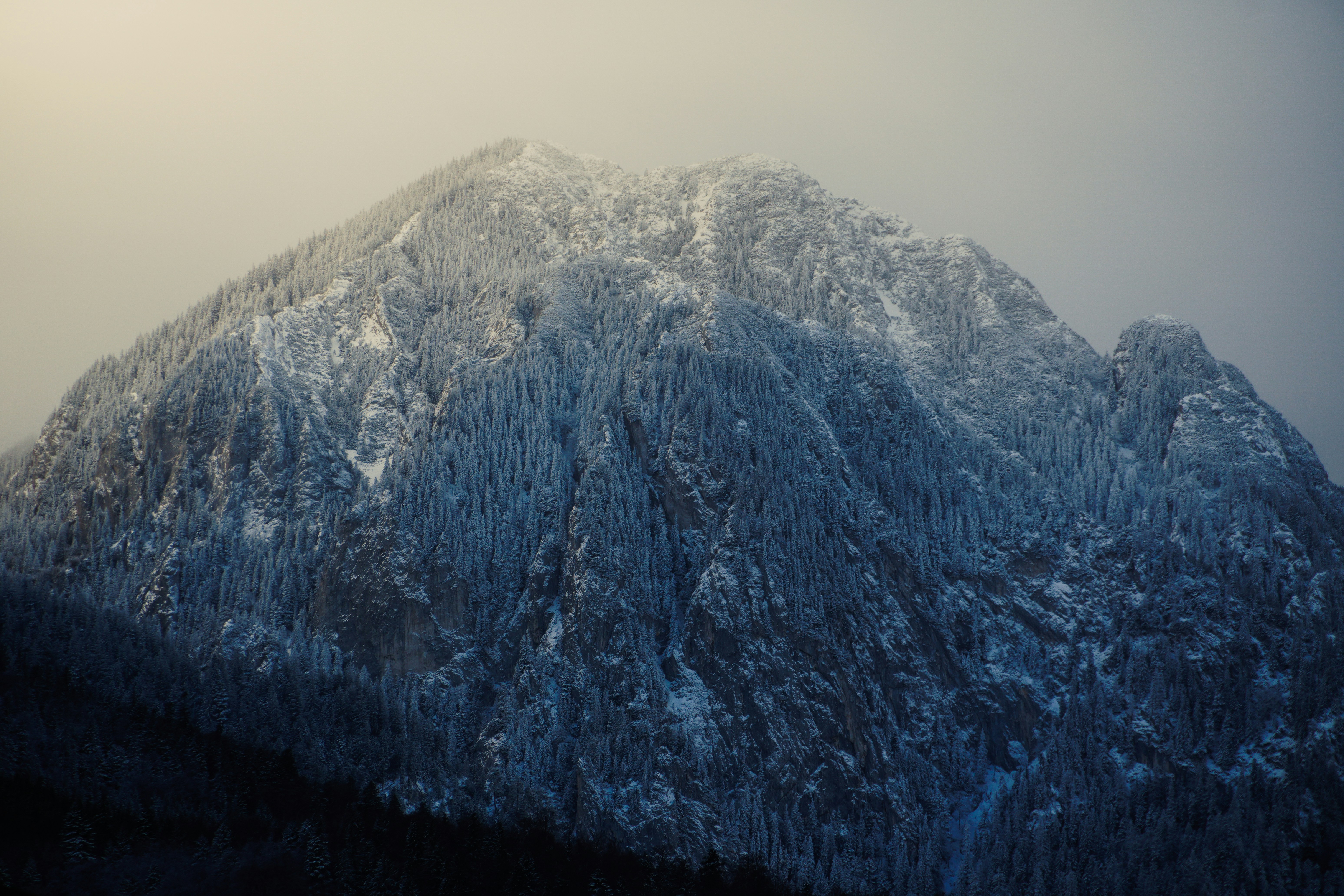 Snow-covered mountain peak under a hazy sky