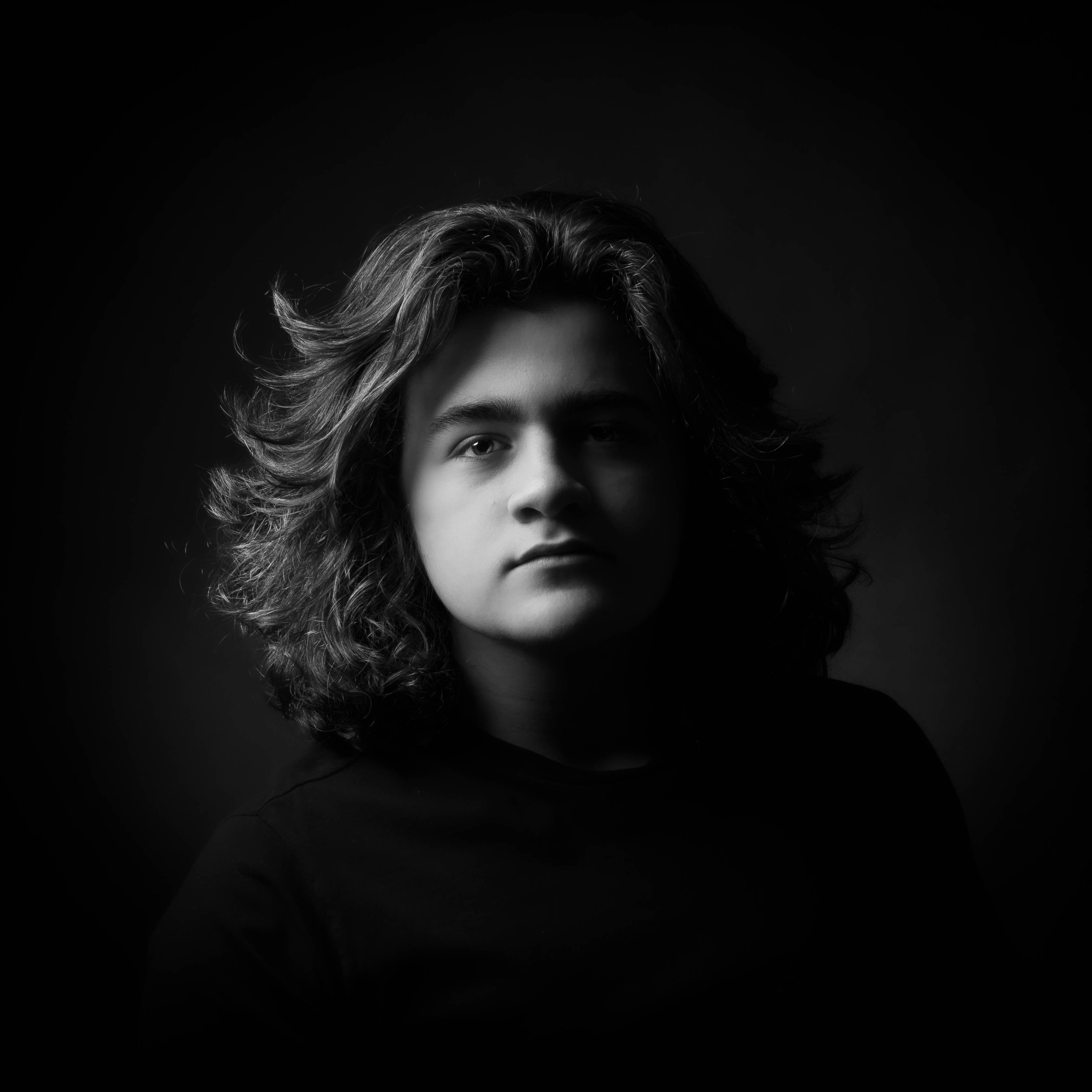 A young person with long, curly hair