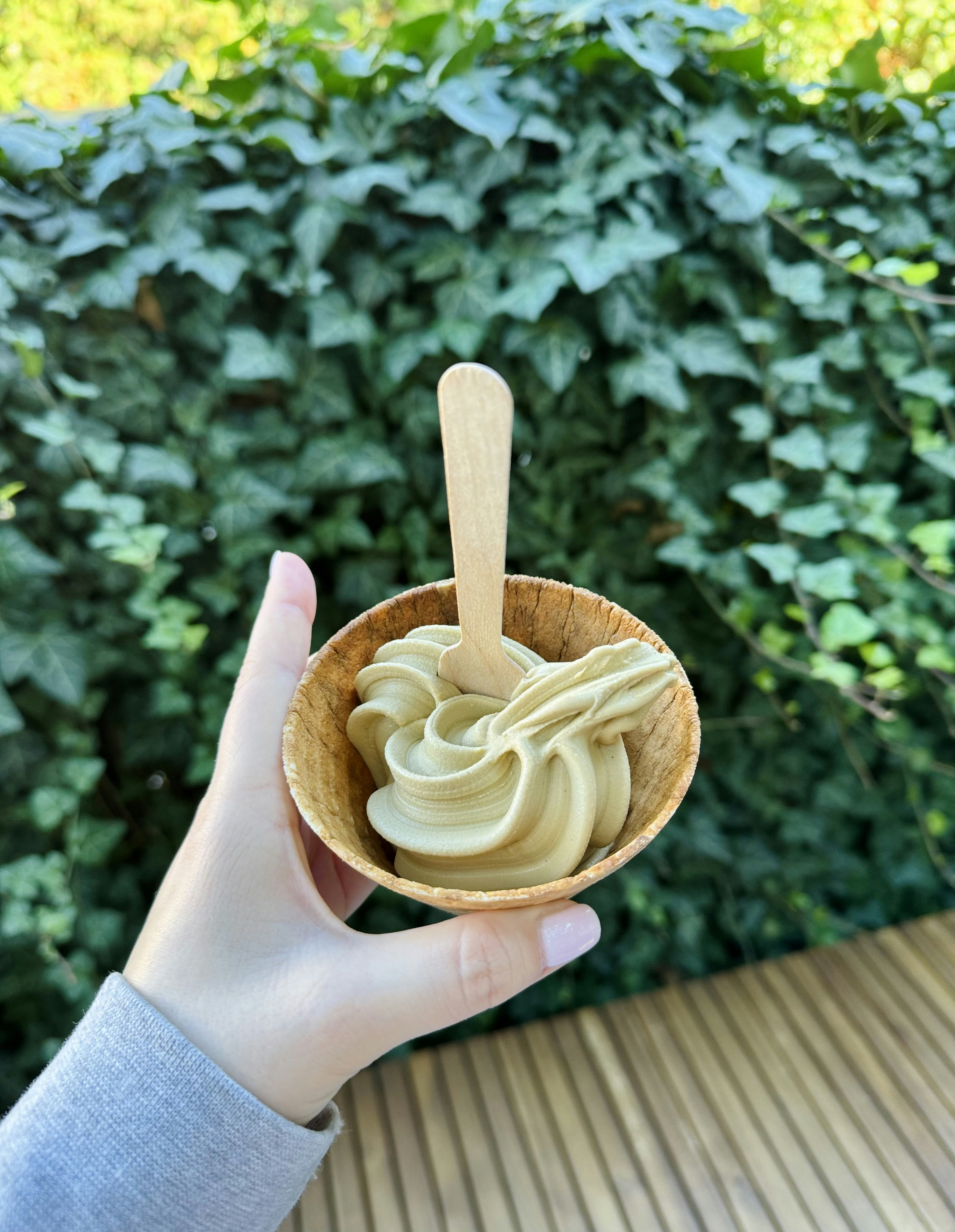 Hand holding a green tea soft serve ice cream cone
