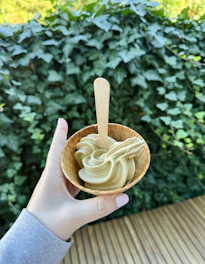 Hand holding a green tea soft serve ice cream cone