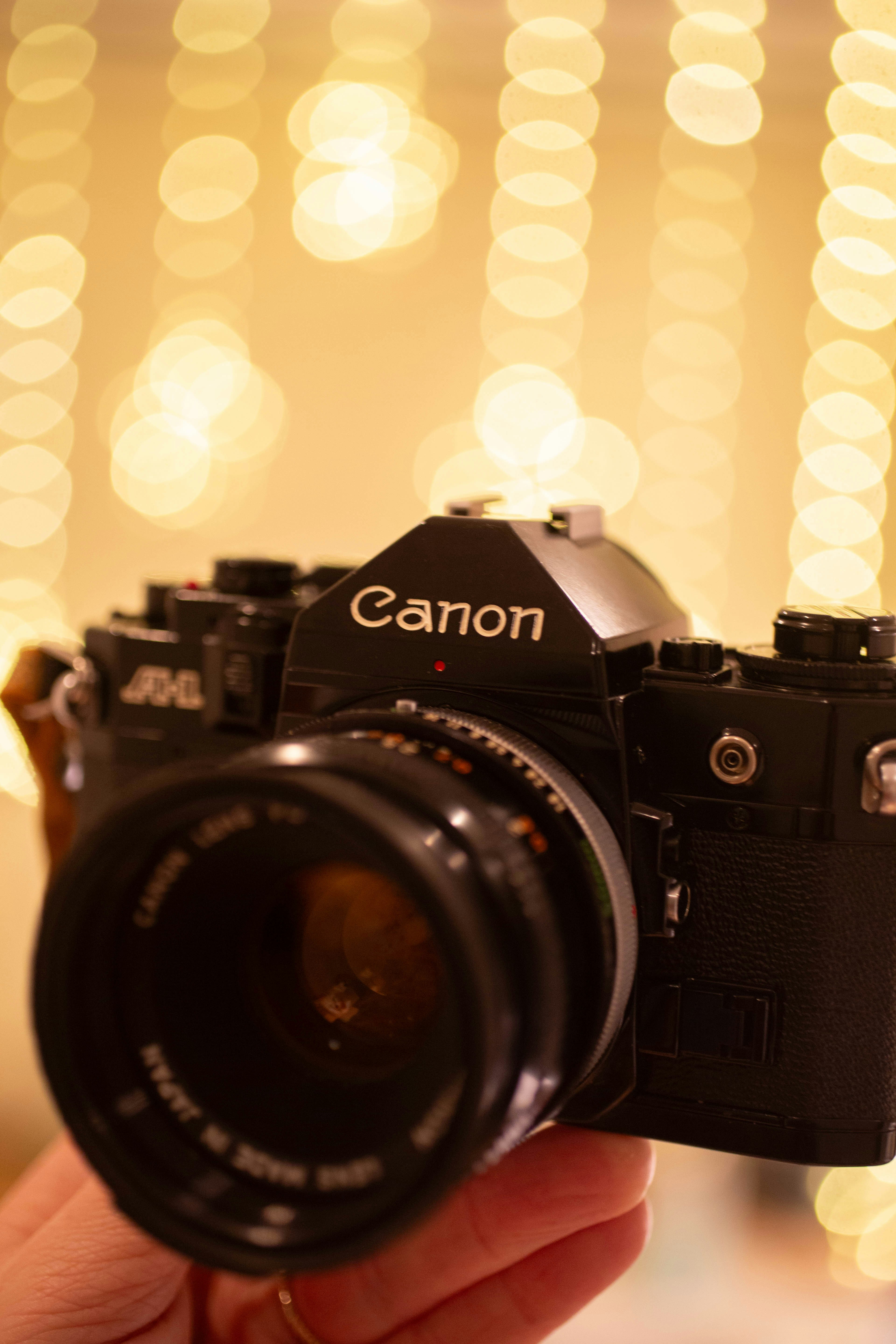 A vintage black canon camera with a lens.